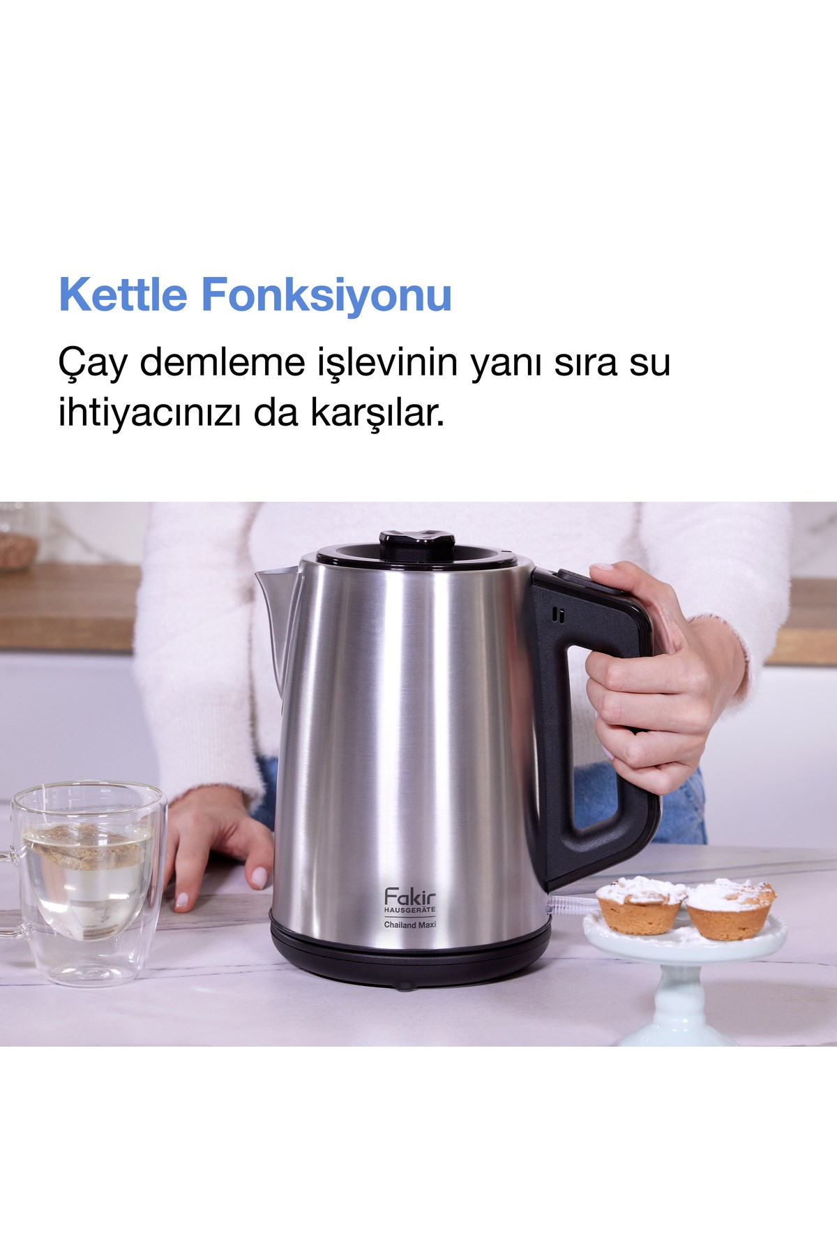Bir kişi siyah saplı gümüş çaydanlığı çay fincanı ve keklerin yanında tutuyor.