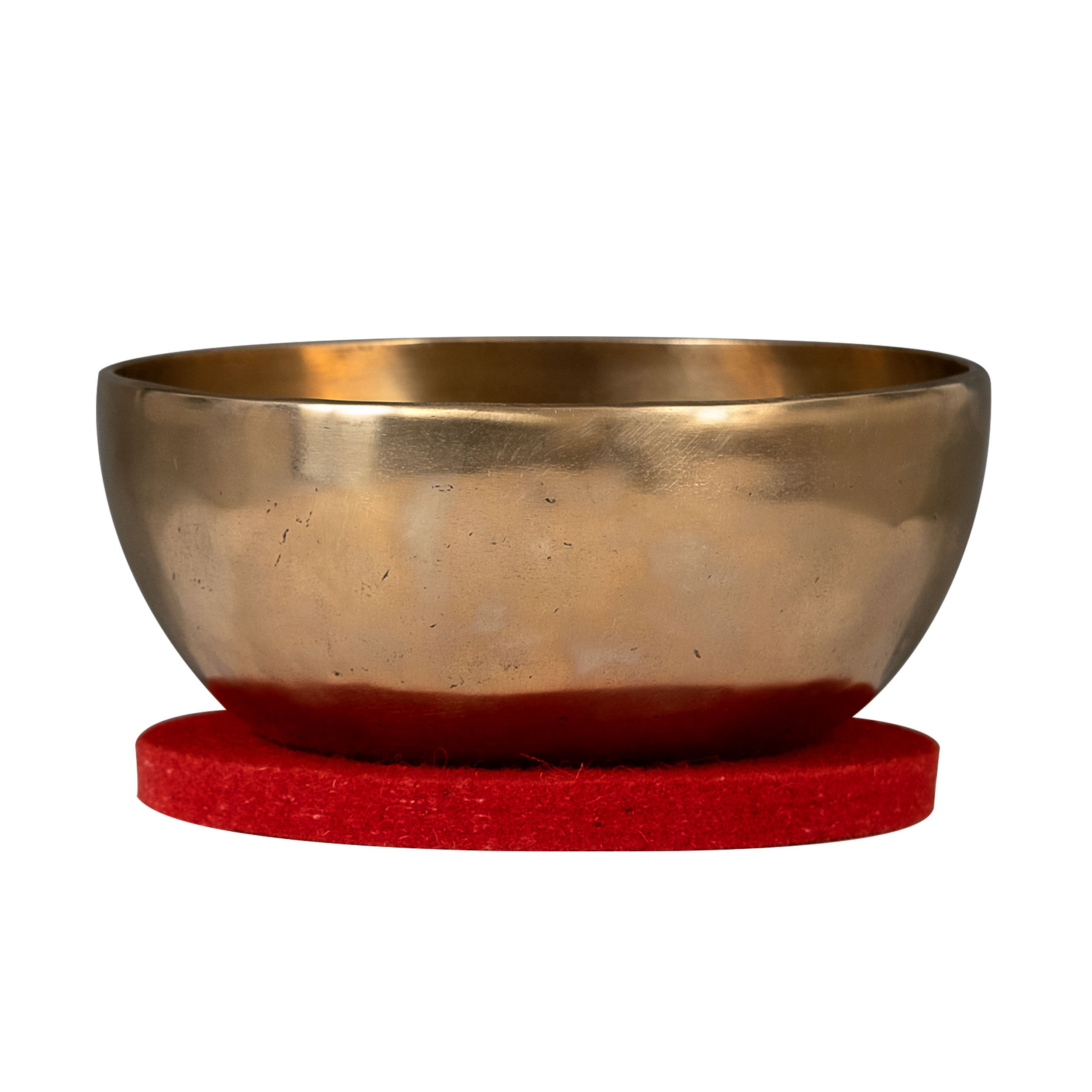 Bronz bir Tibet kasesi kırmızı keçe mat üzerinde duruyor.