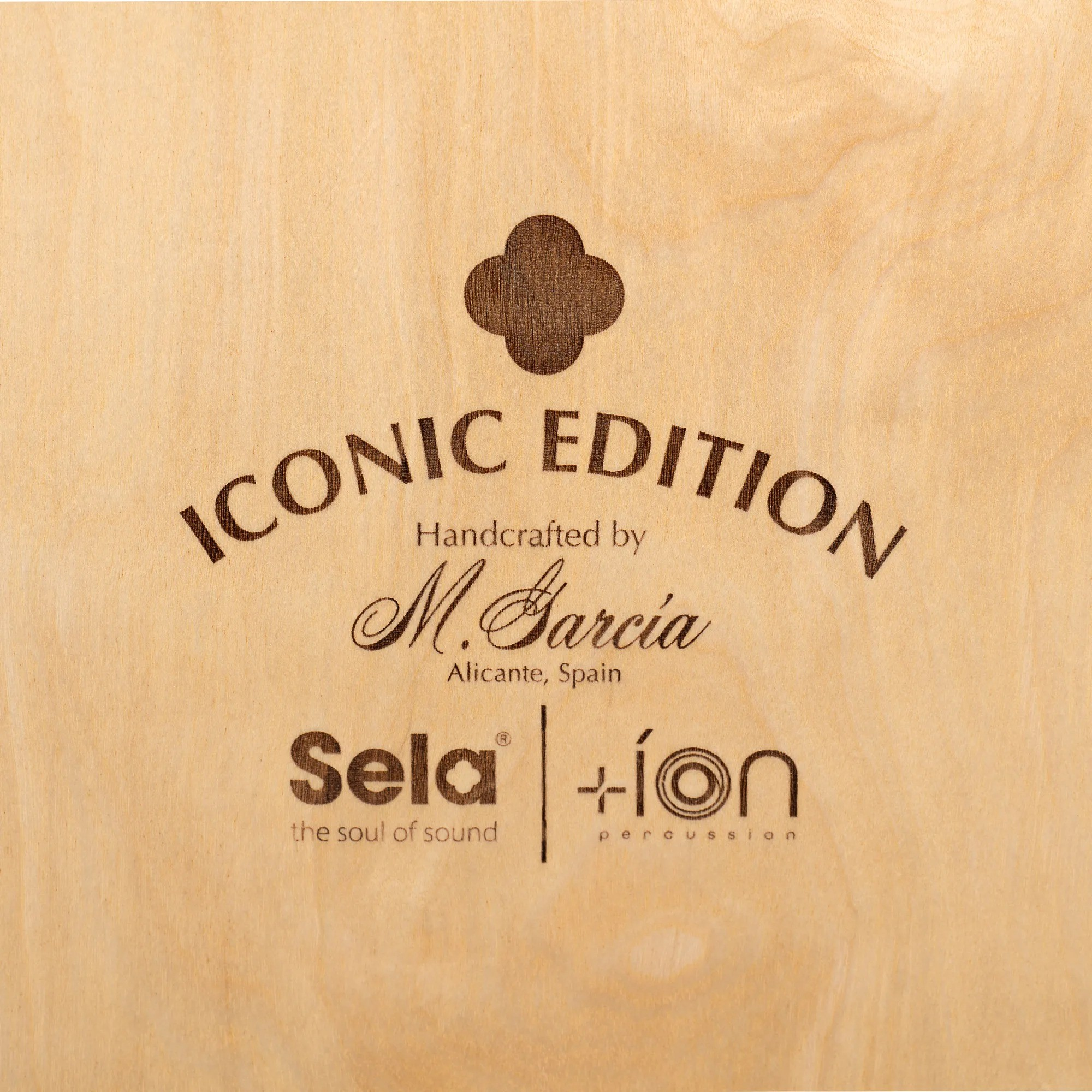Ahşap yüzeyde "ICONIC EDITION" yazısı ve logolar.