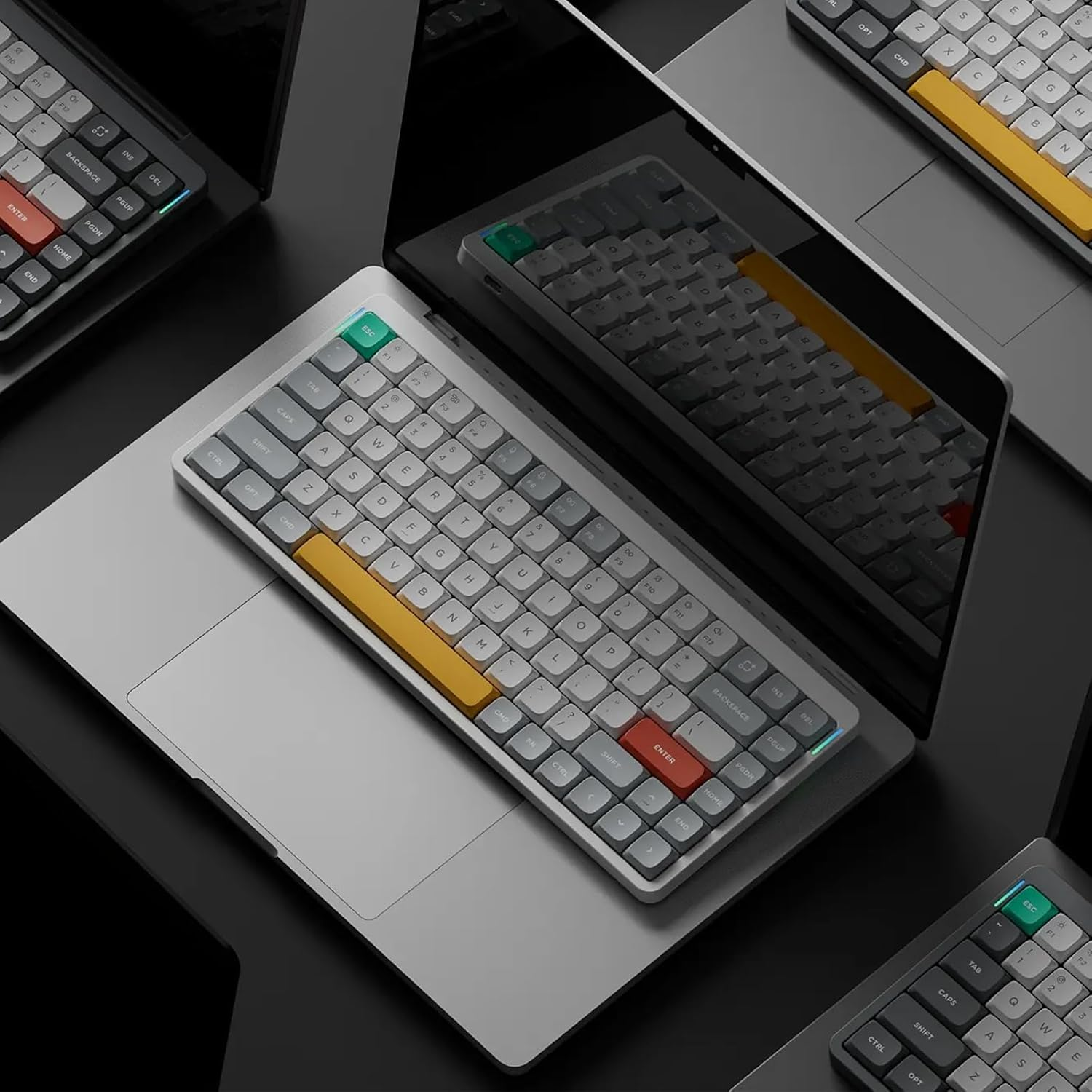 Szare i czarne klawiatury na laptopach z żółtymi i czerwonymi klawiszami.