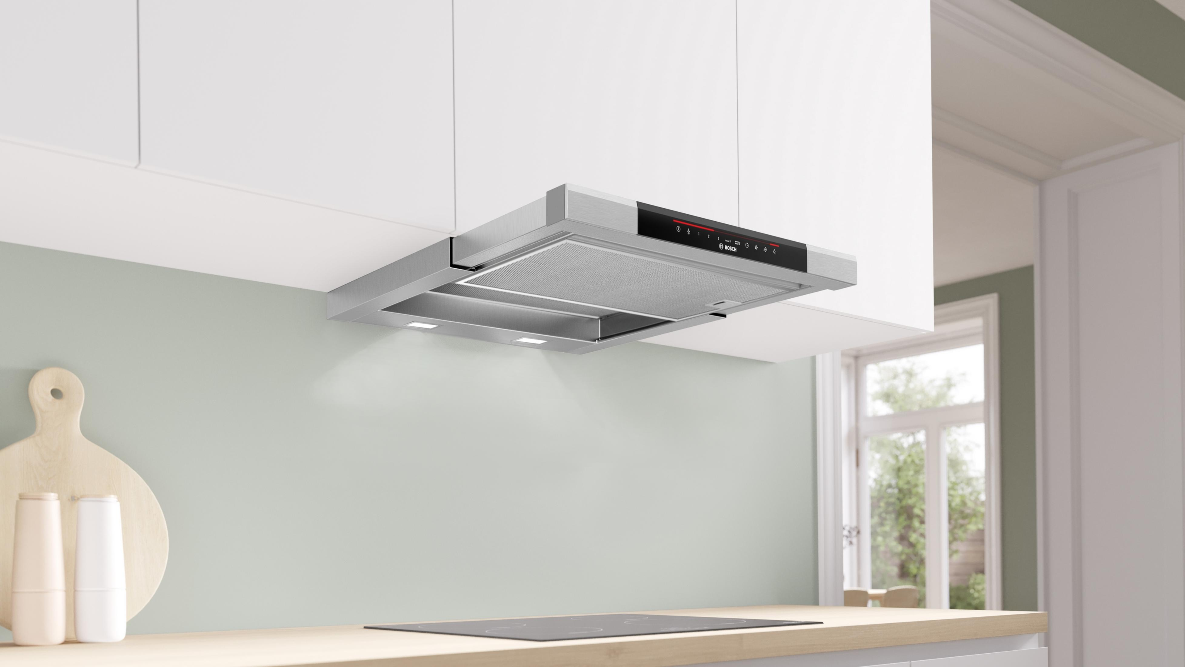 A modern kitchen with a stainless steel range hood above a stovetop.