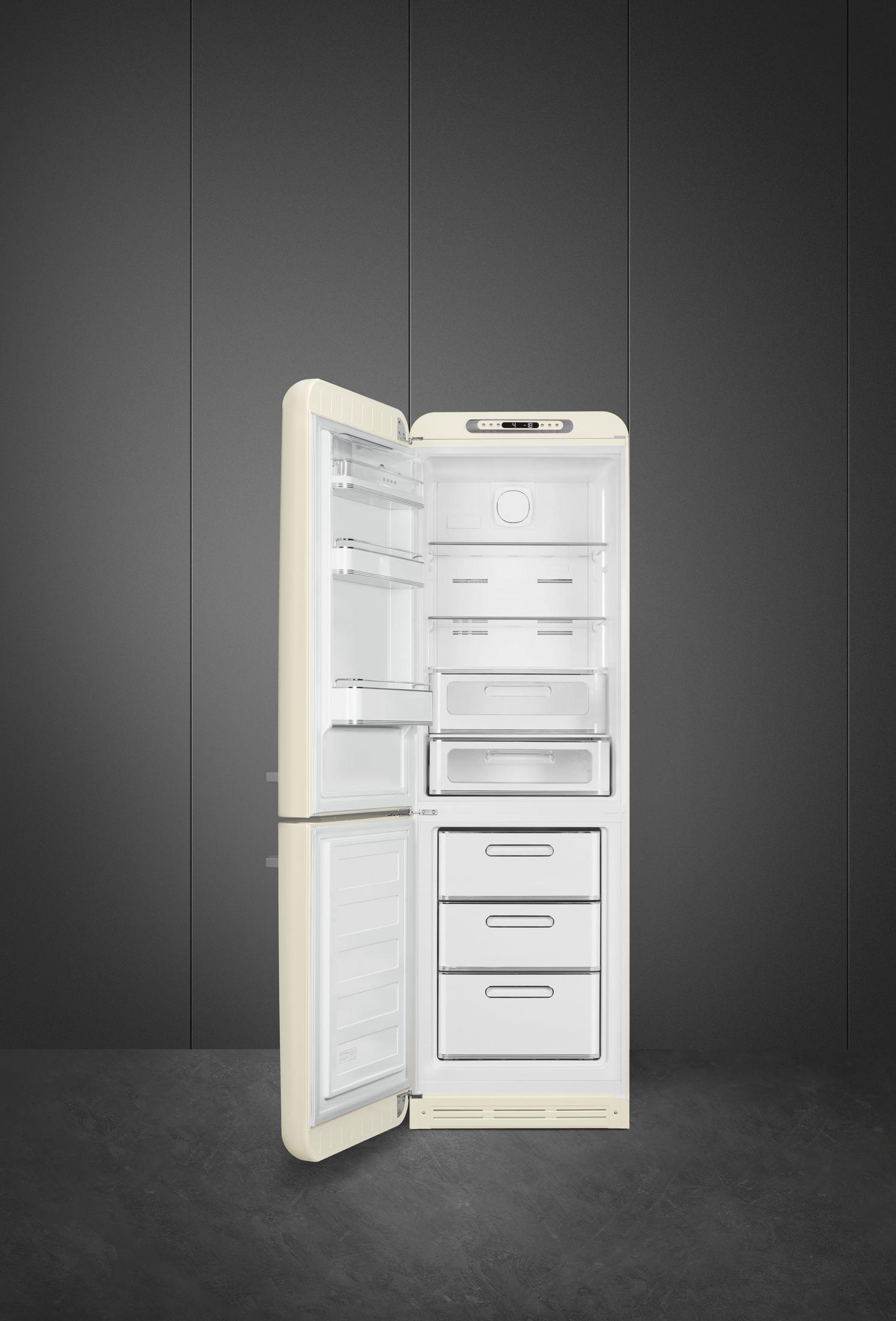 Un refrigerador color crema con la puerta abierta frente a una pared gris.