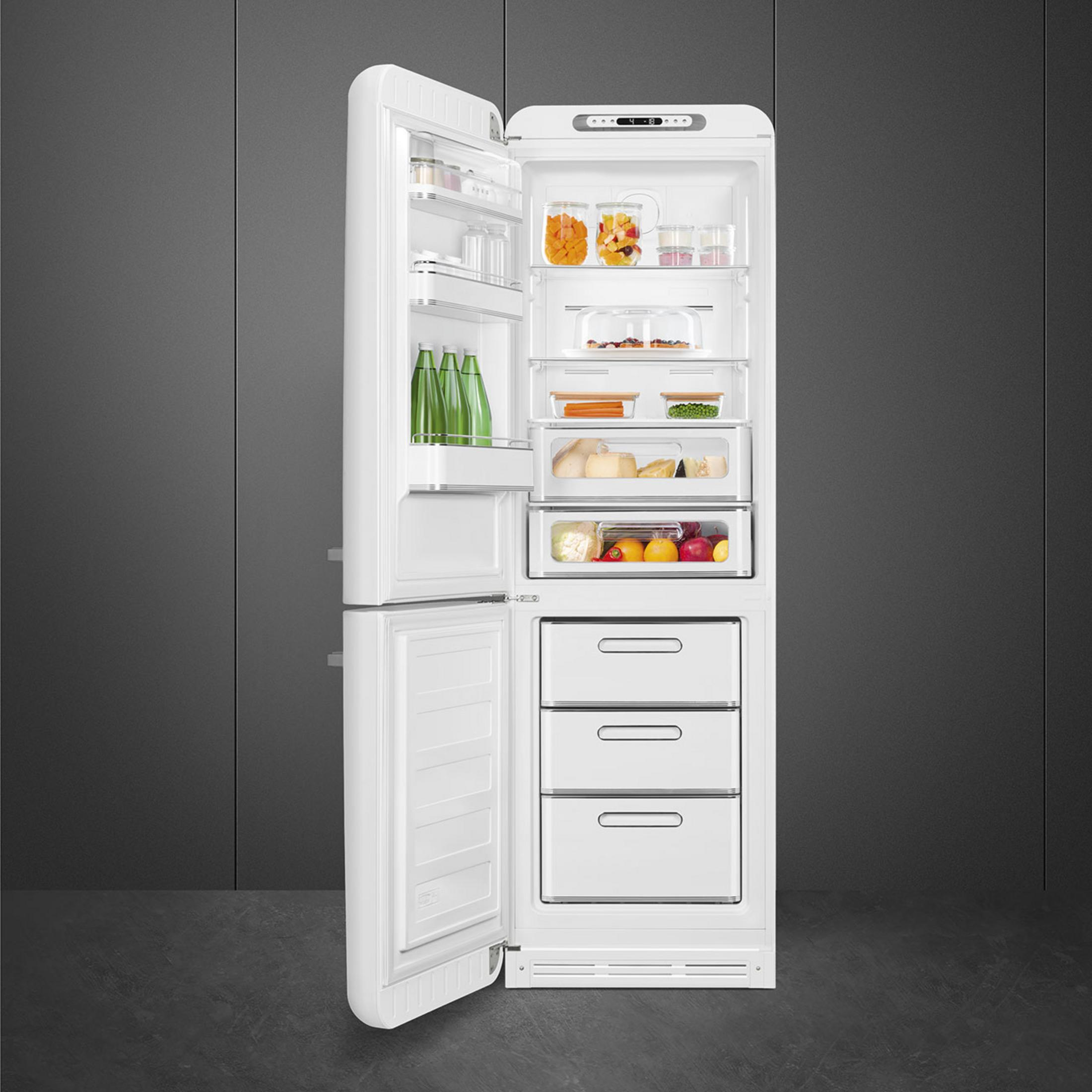 Un frigorífico blanco abierto lleno de comida. Botellas verdes, frutas, verduras, queso y recipientes.