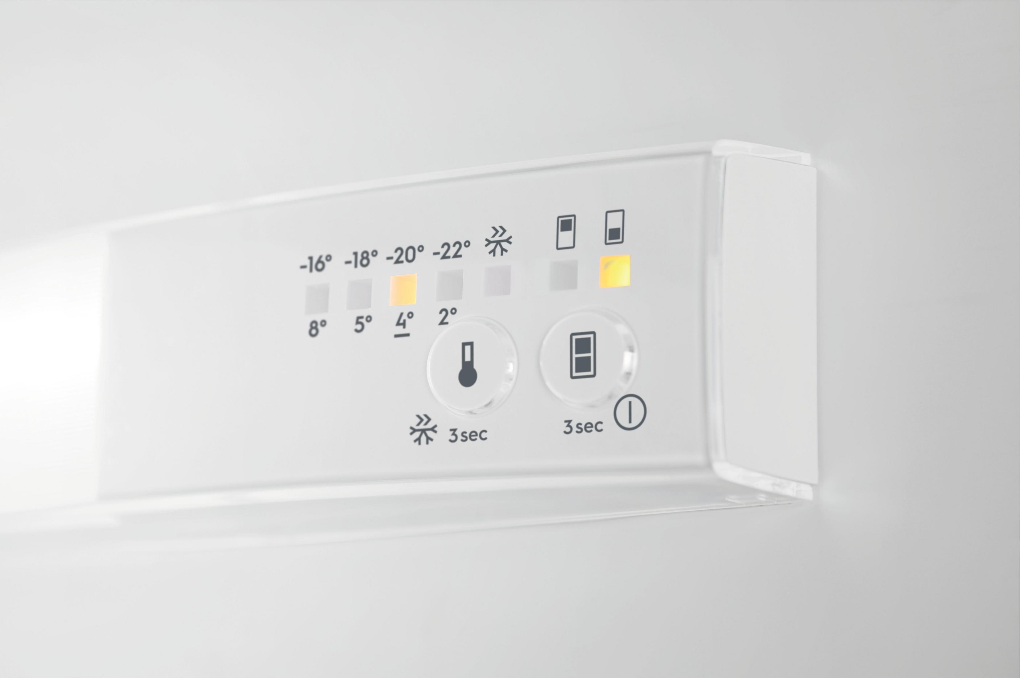 Panel de control blanco con indicadores de temperatura y símbolos. Una luz naranja encendida.