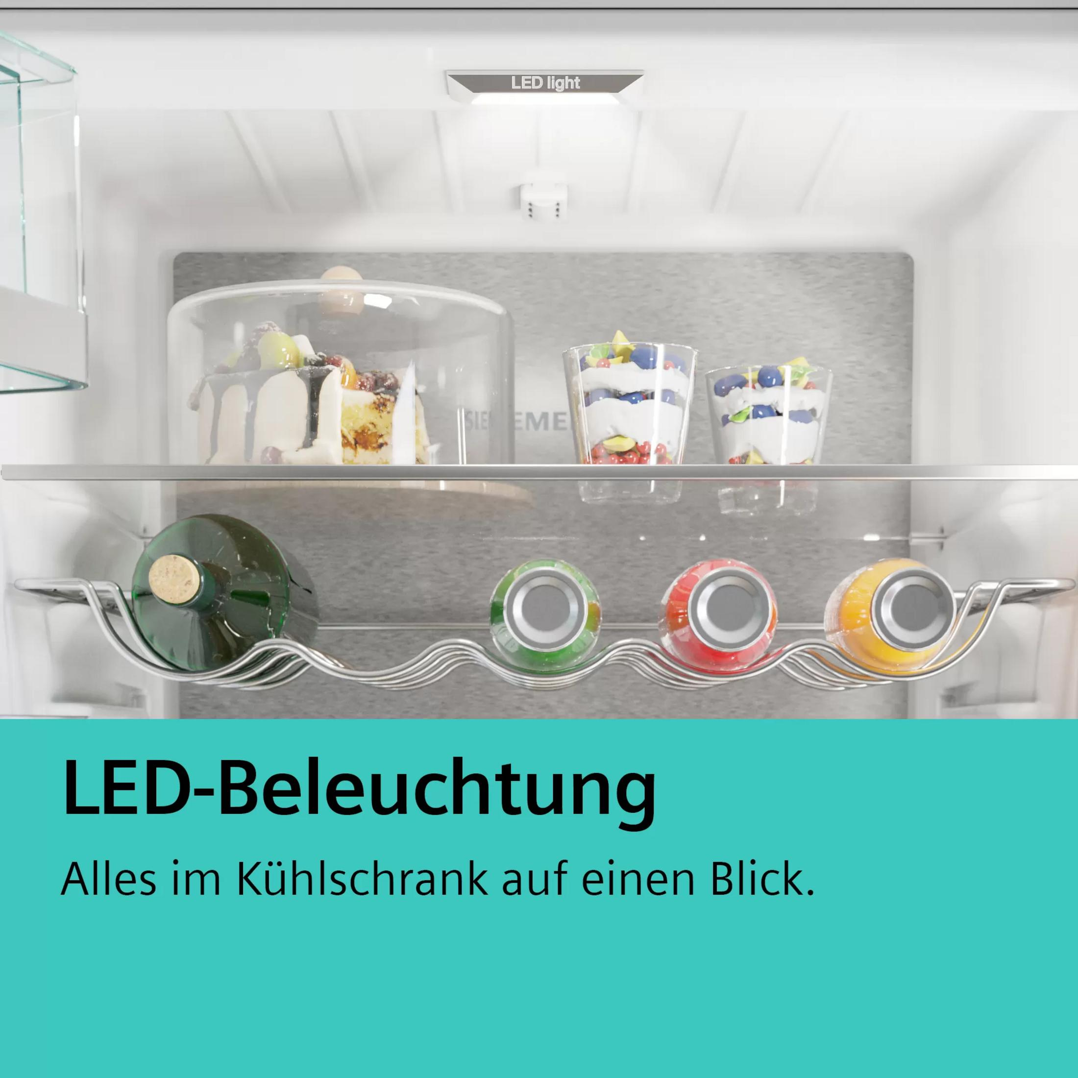 Kühlschrankinnenraum mit LED-Beleuchtung, Kuchen, Desserts, Flasche und Dosen.
