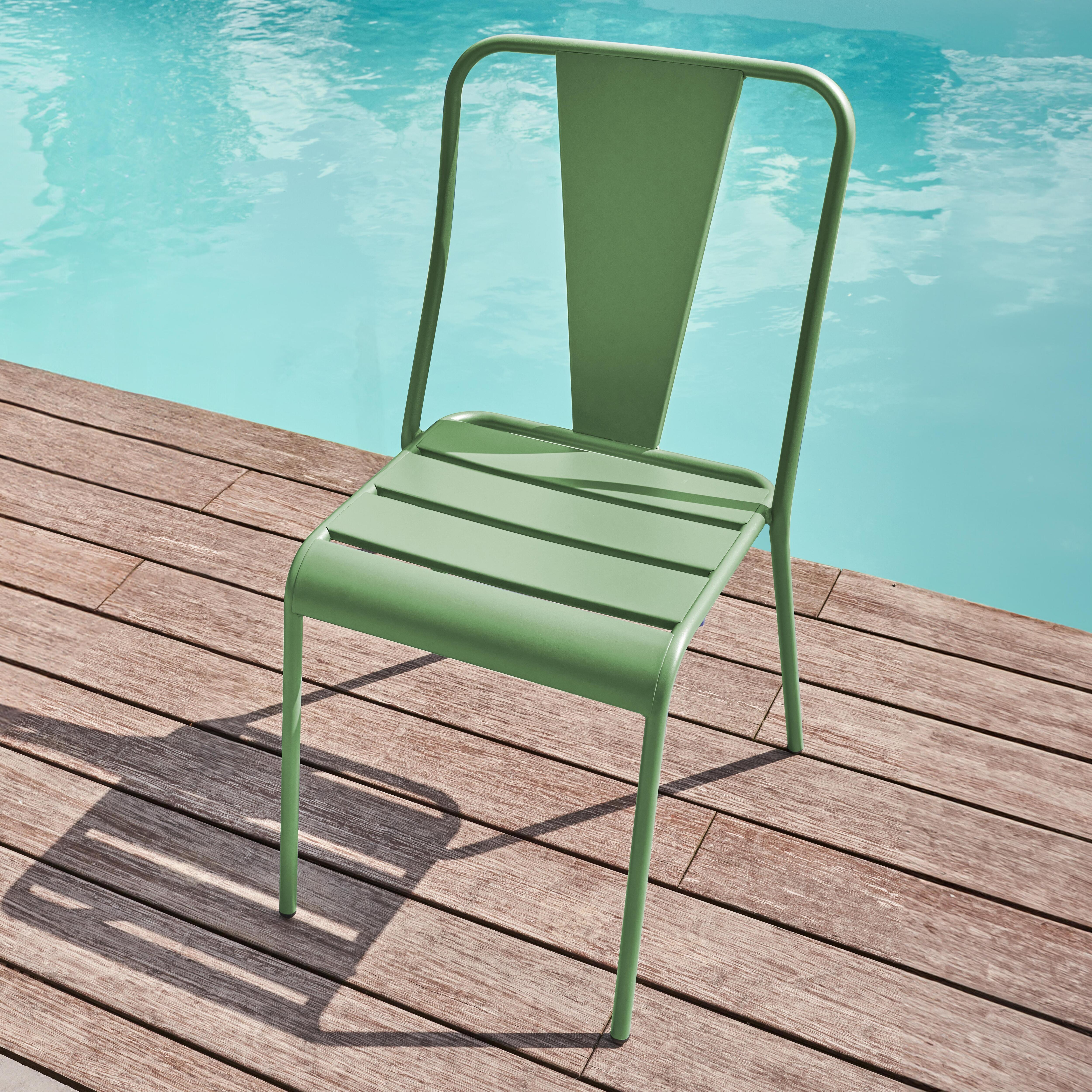 Grüne Metallstuhl am Poolrand auf Holzdeck.