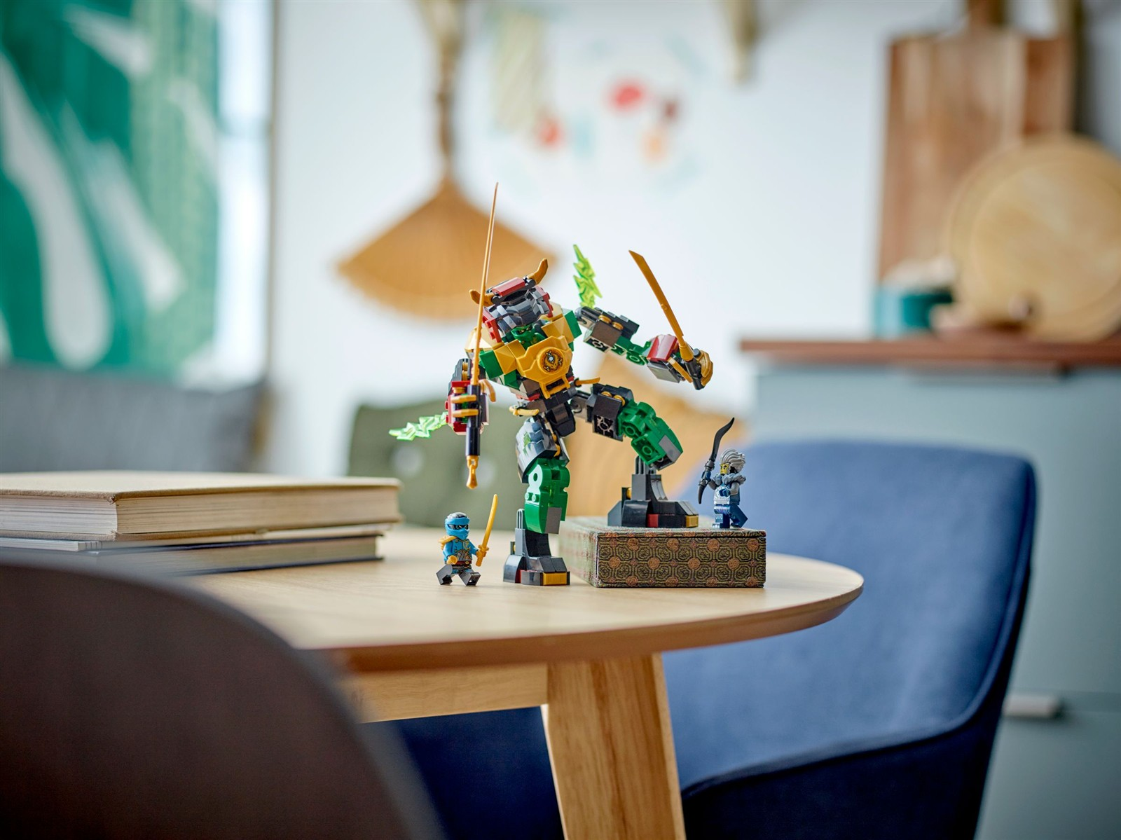 Ein grüner Lego-Mech mit zwei Minifiguren und Büchern auf einem Holztisch.