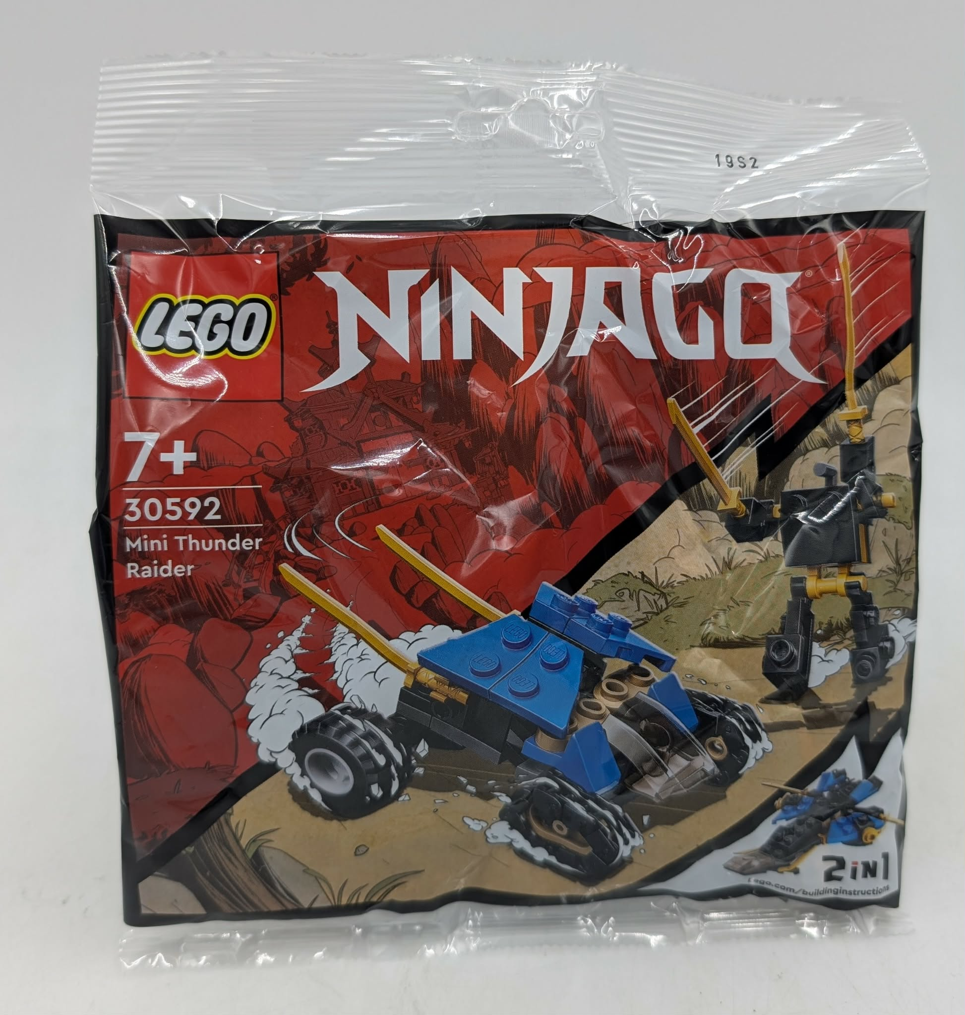 LEGO Ninjago 30592 Mini Thunder Raider avec véhicule bleu et robot noir sur terrain sablonneux.