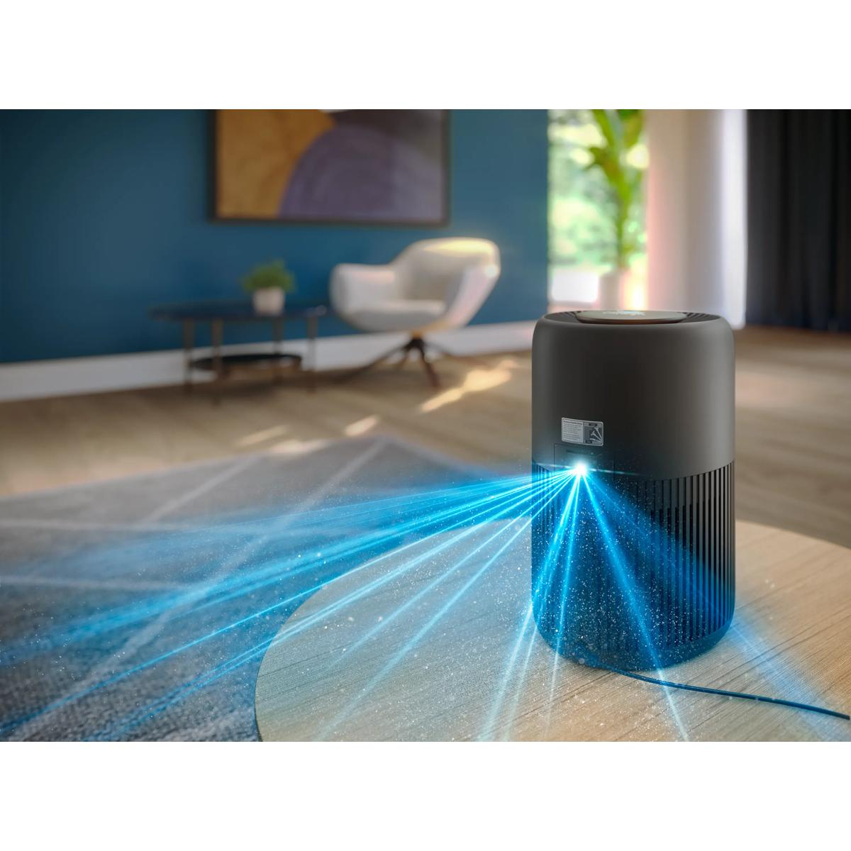 Czarny oczyszczacz powietrza na stole emituje niebieskie strumienie powietrza.