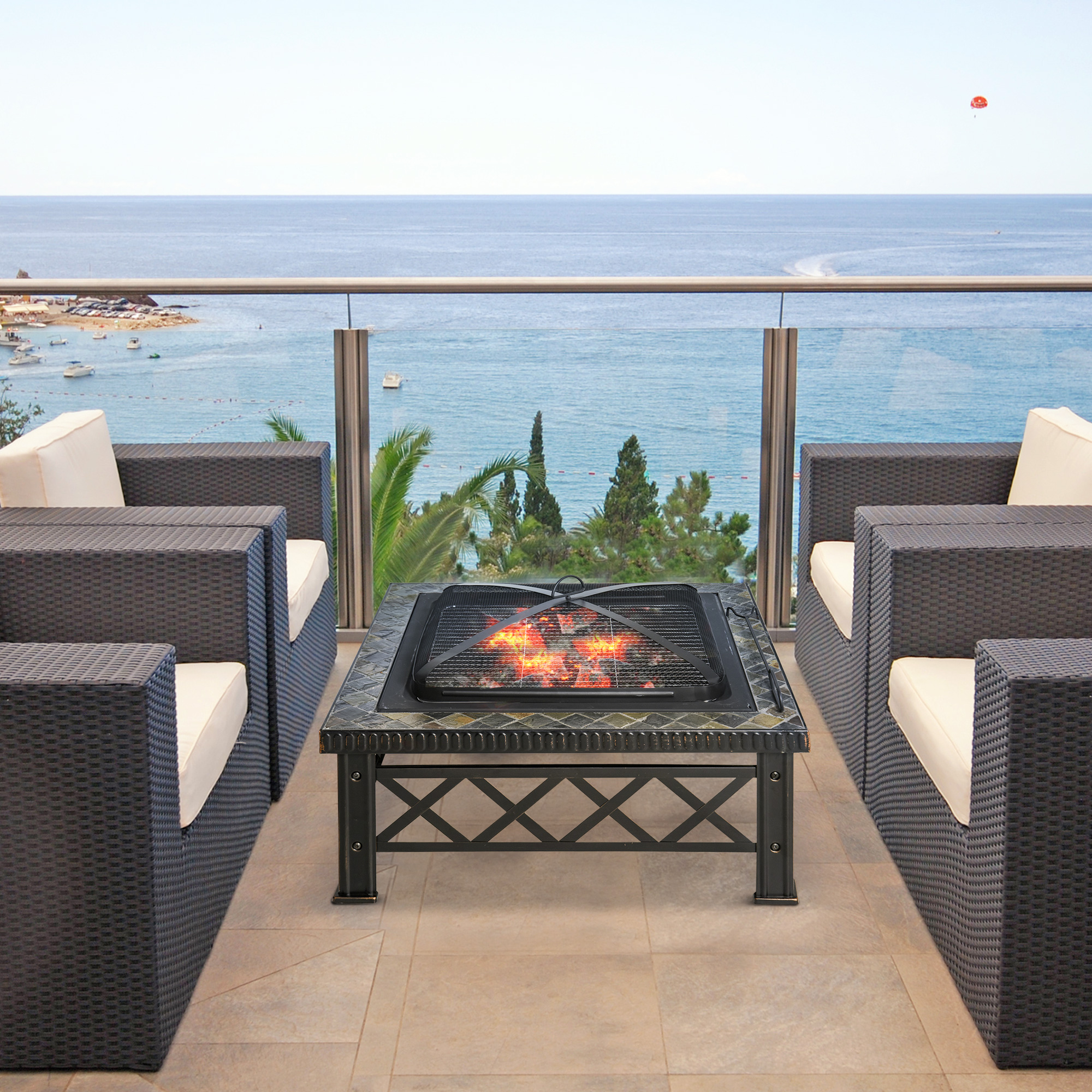 Patio con mobili in vimini, braciere e vista sull'oceano.