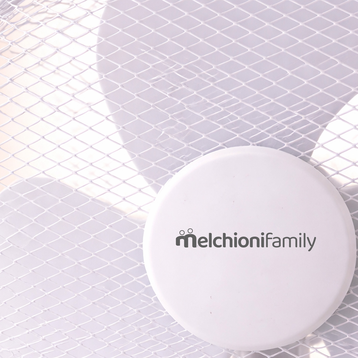 Un ventilador blanco con rejilla y el logo 'melchionifamily'.