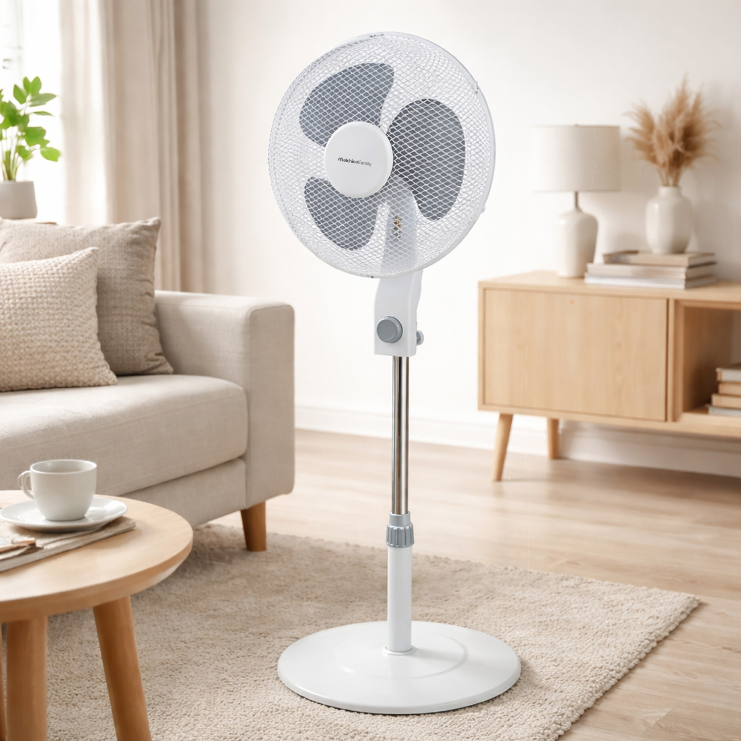 Un ventilador de pie blanco está sobre una alfombra en una sala de estar con sofá y mesa.