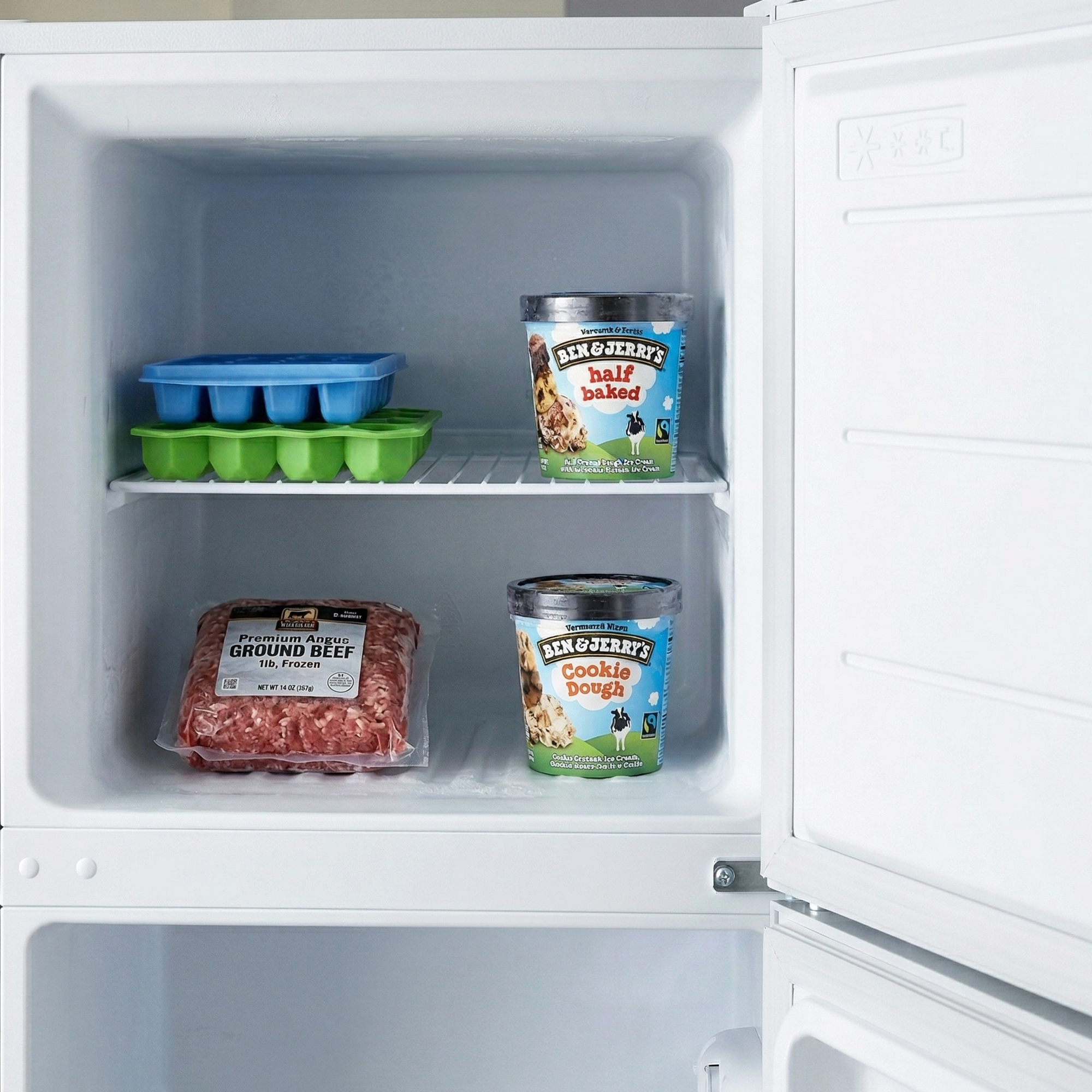 Vriezer met rundergehakt en twee bakken Ben & Jerry's ijs.