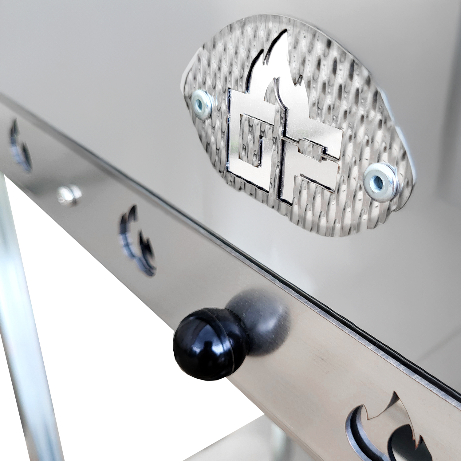 Nahaufnahme eines silbernen Grills mit Flammenlogo und schwarzem Knopf. Modernes Design.