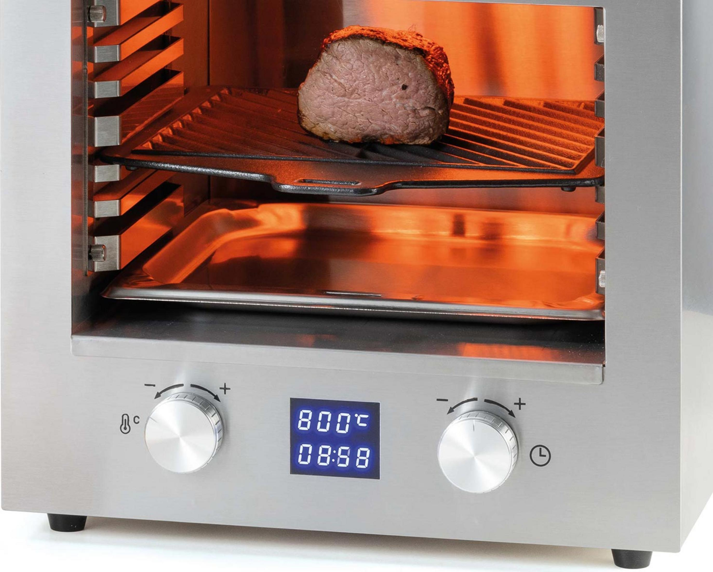Ein Braten gart in einem silbernen Ofen auf einem Rost. Unten befindet sich eine Auffangschale.