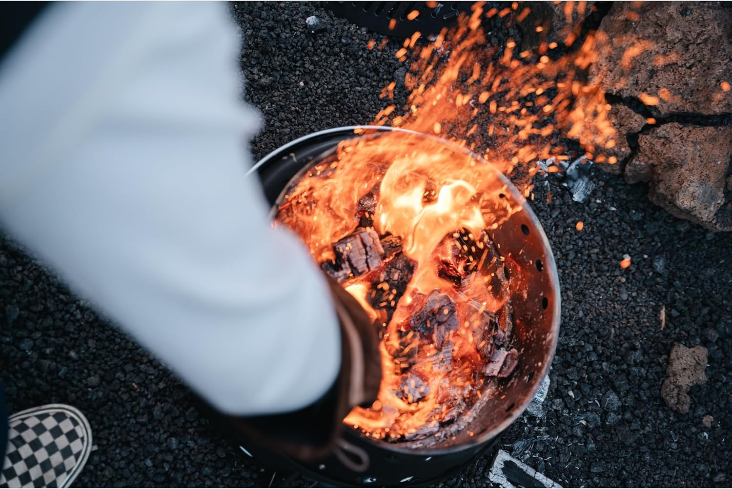 Ein Grill brennt mit heißen Kohlen und Flammen, Funken fliegen.