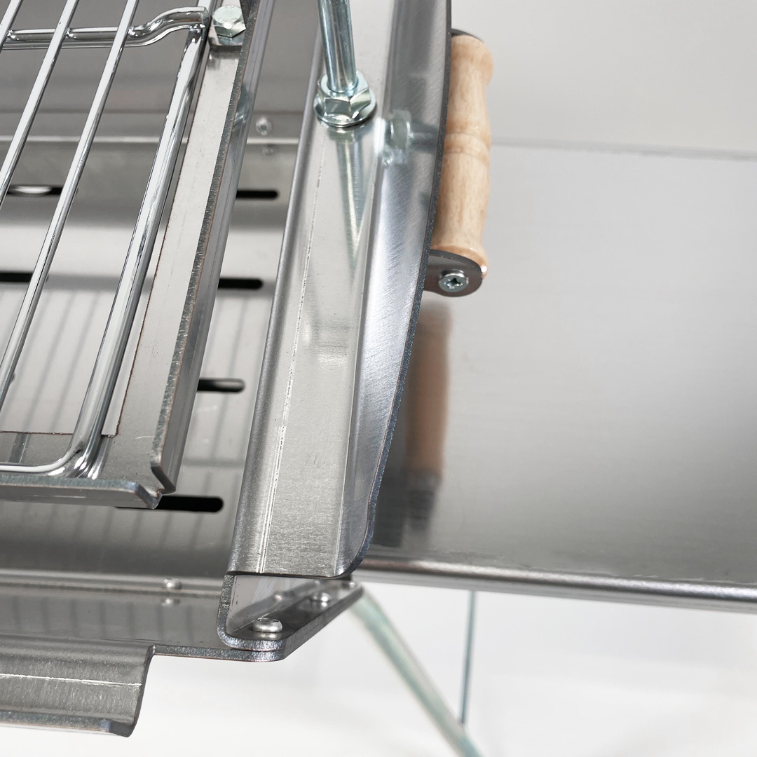 Detailansicht eines silbernen Grills mit Holzgriff und Metallstreben.