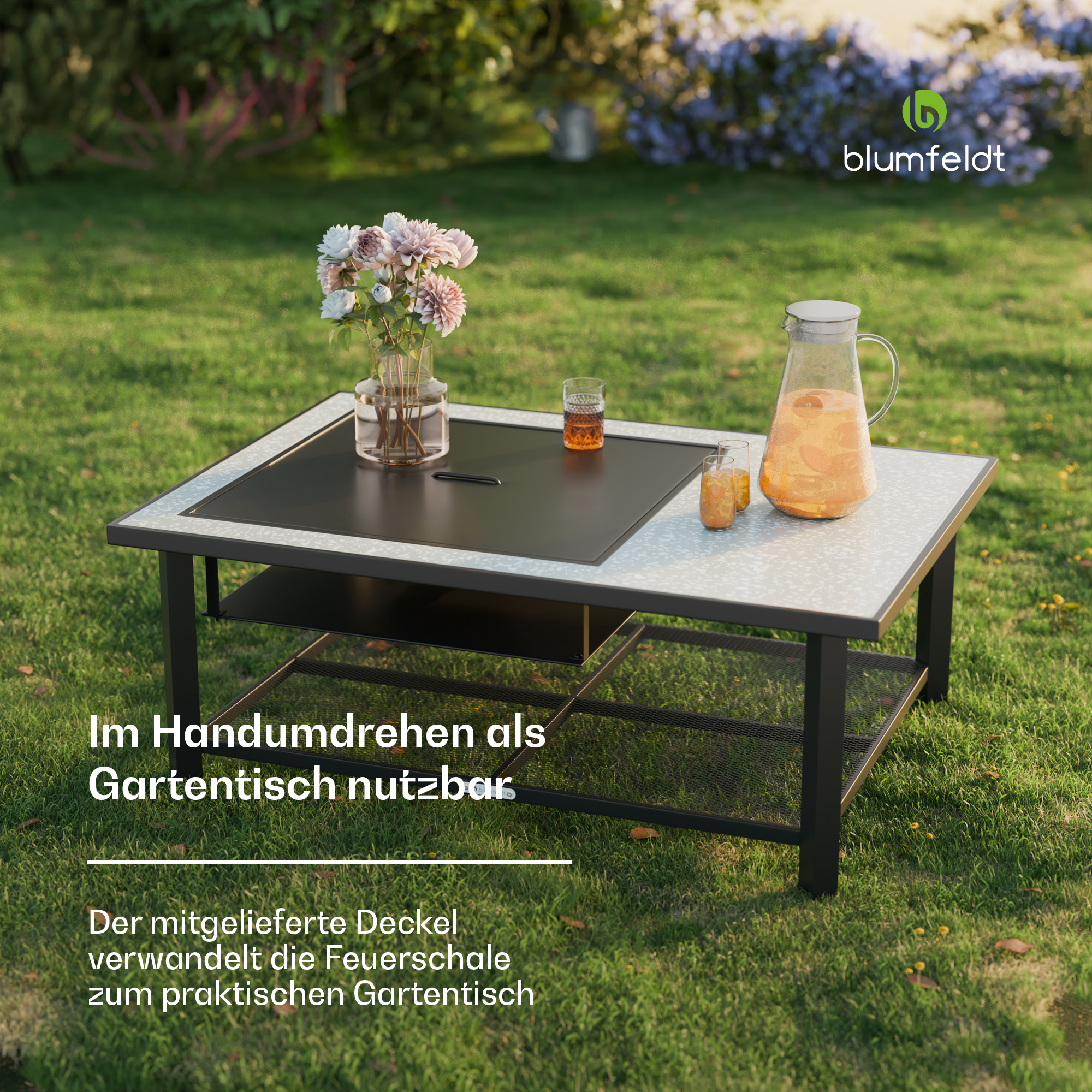 Gartentisch mit Blumen, Saftkrug und Gläsern im Freien.