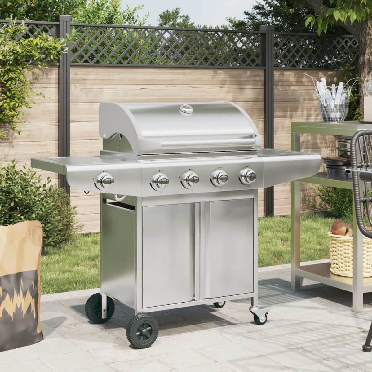 Ein glänzender Gasgrill aus Edelstahl mit vier Brennern steht auf einer Terrasse. Links eine Holzkohletüte.