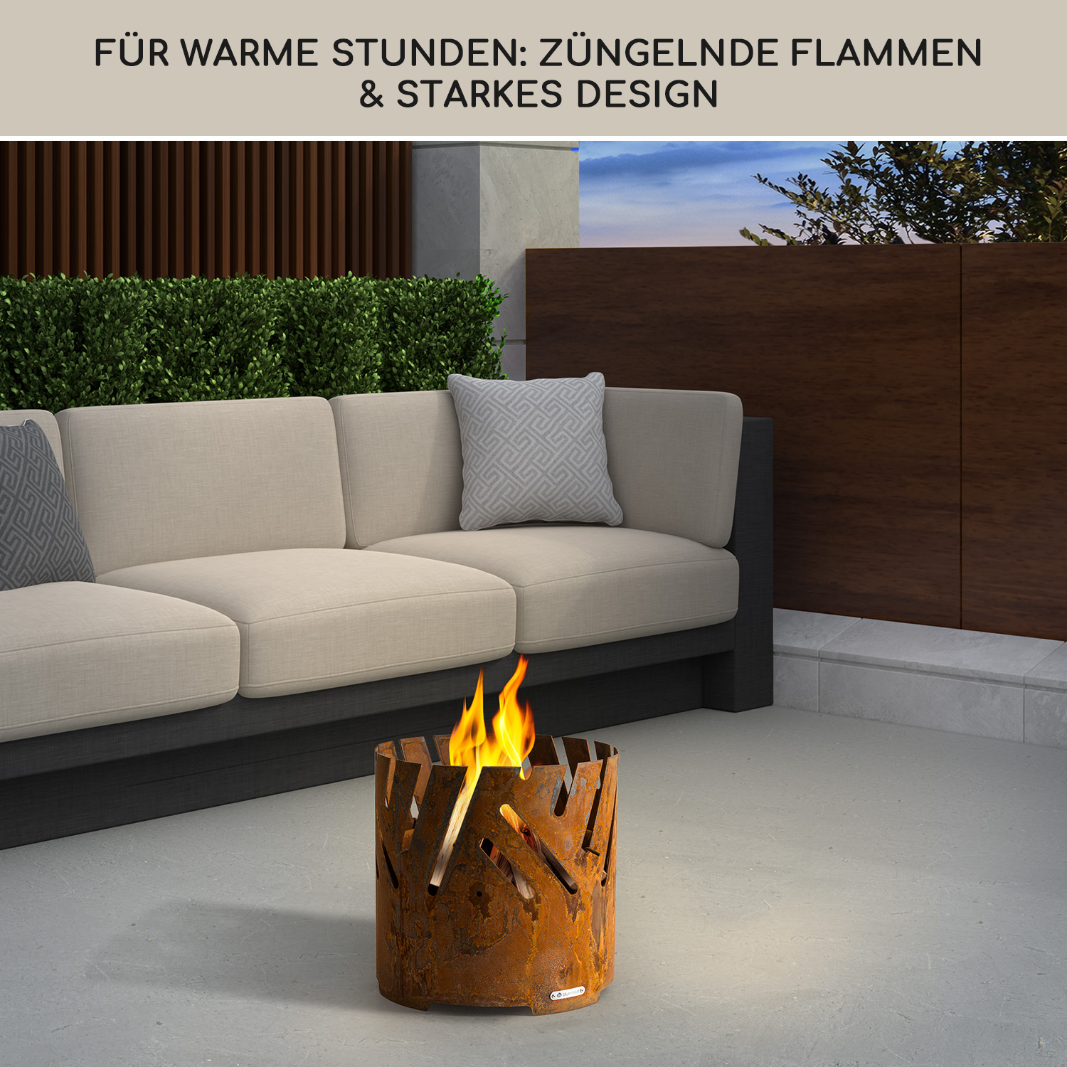 Rostige Feuerstelle mit Flammen vor einem Sofa im Freien.