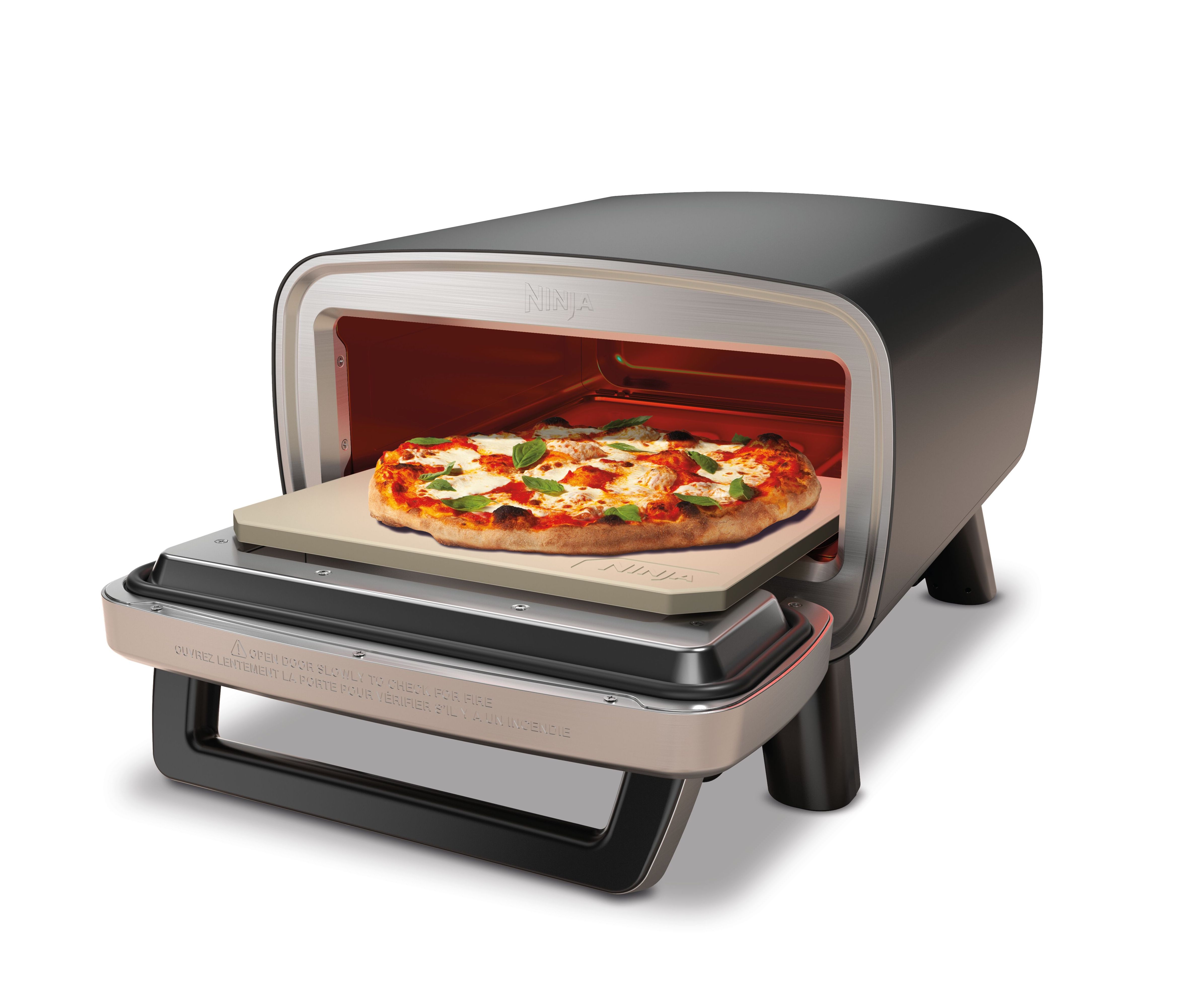 Une pizza cuite dans un four Ninja sur une pierre à pizza, porte ouverte.