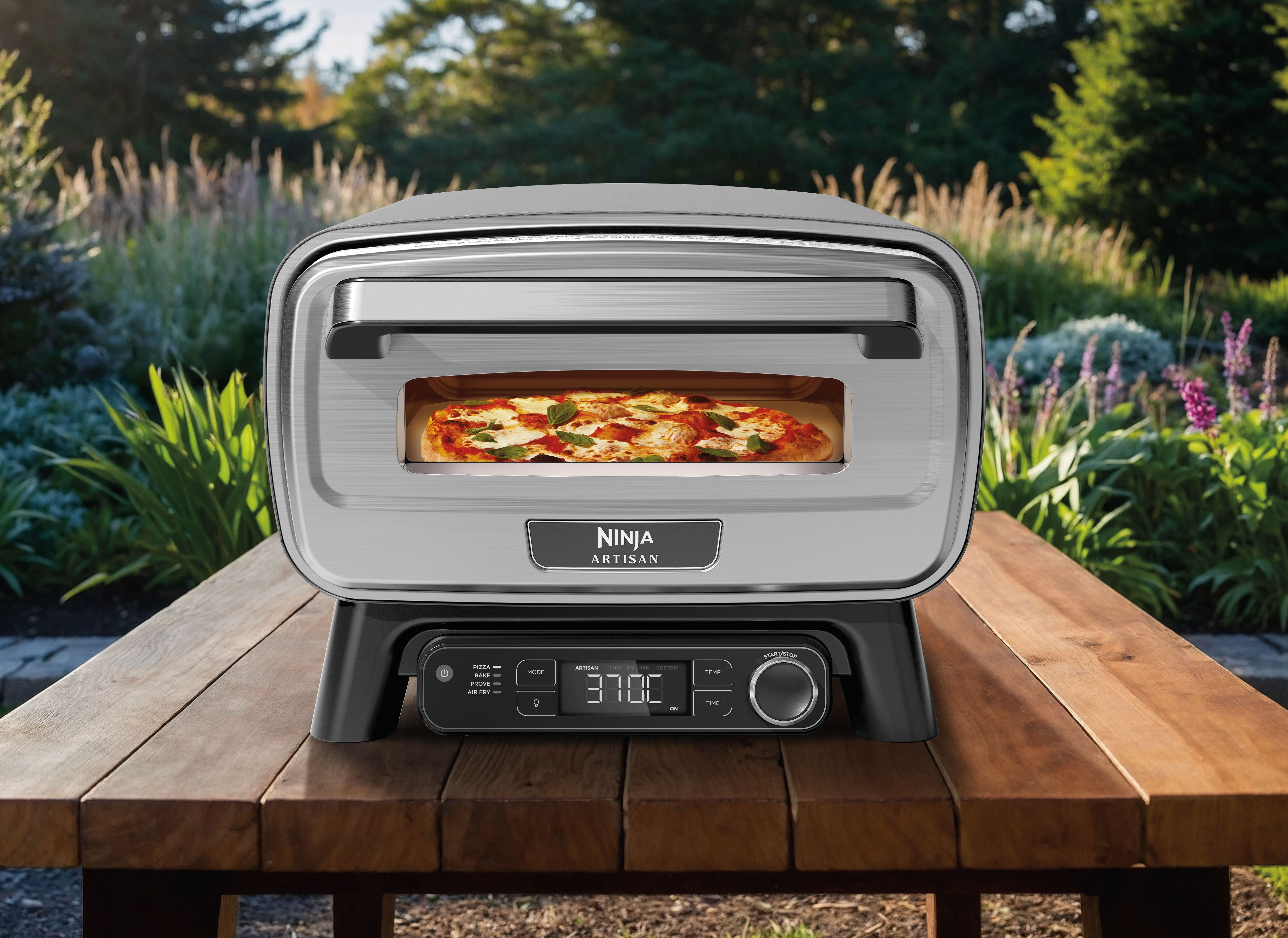 Un four à pizza Ninja Artisan avec une pizza cuite sur une table en bois extérieure.