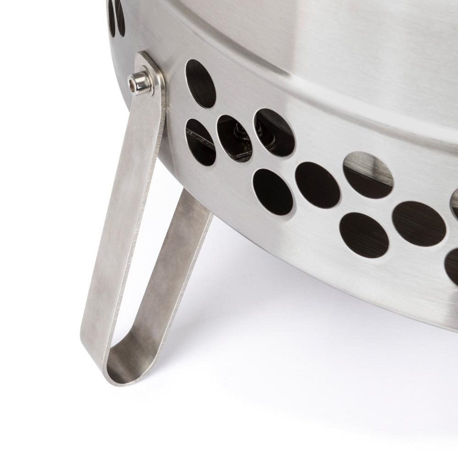 Nahaufnahme eines silbernen Grills mit runden Lüftungslöchern und einem Metallbein.