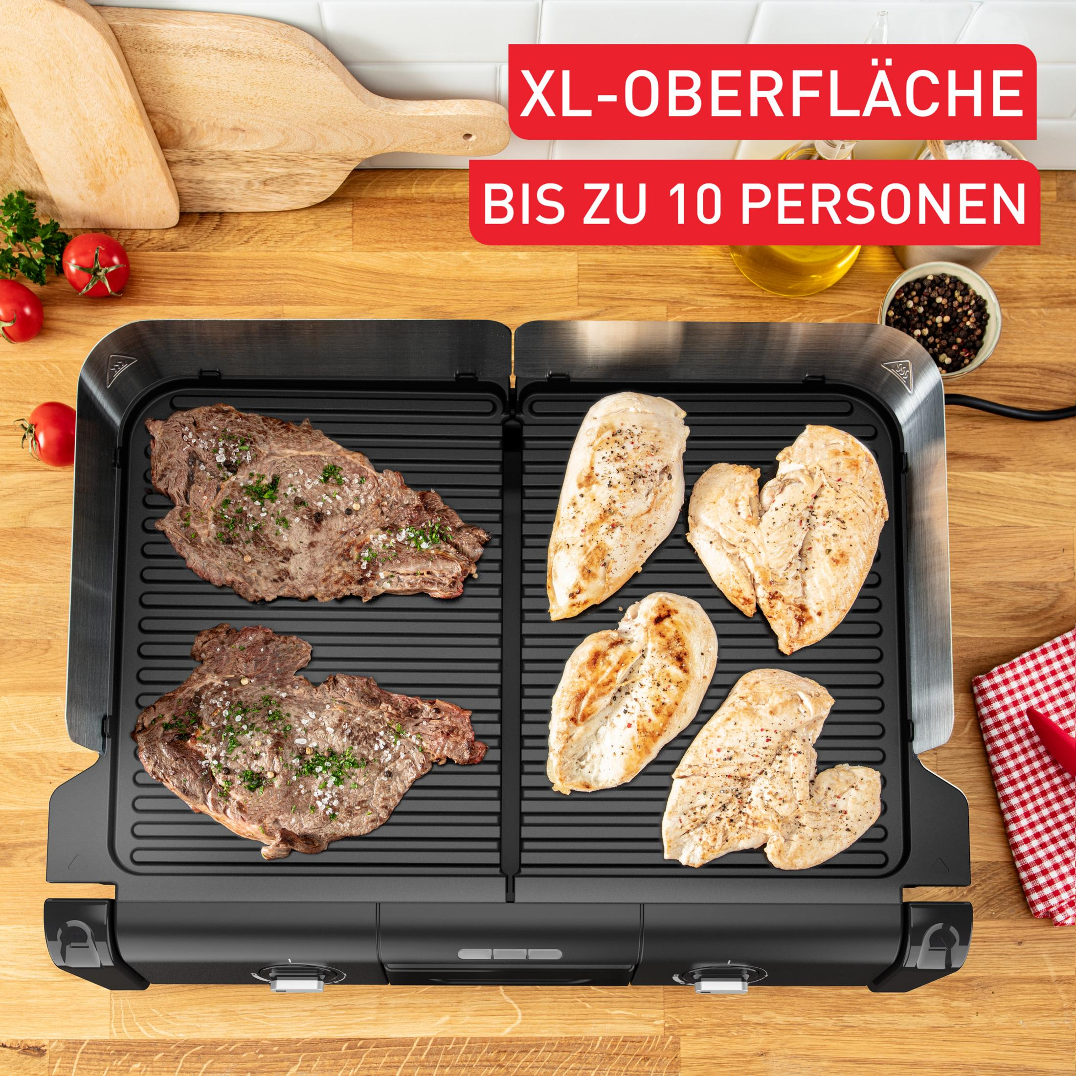 Ein Grill mit zwei Steaks und vier Hähnchenbrüsten, garniert mit Kräutern und Gewürzen.