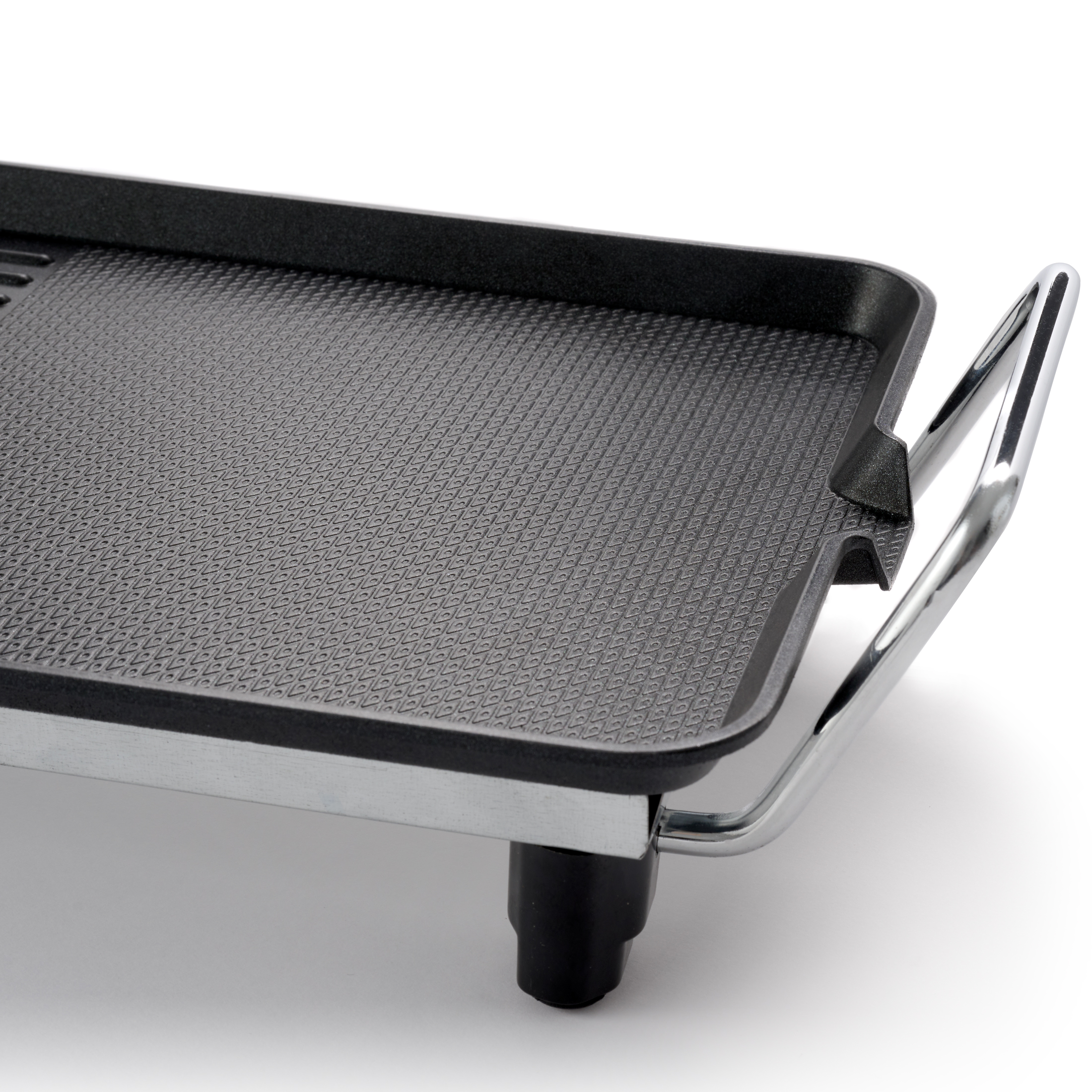 Close-up of a black electric grill plate with a patterned surface and chrome handles on white.