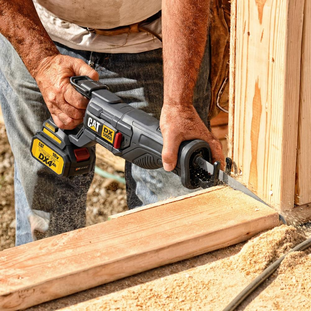 Bir kişi ahşap kesmek için sabre testere kullanıyor. Talaş uçuşuyor.