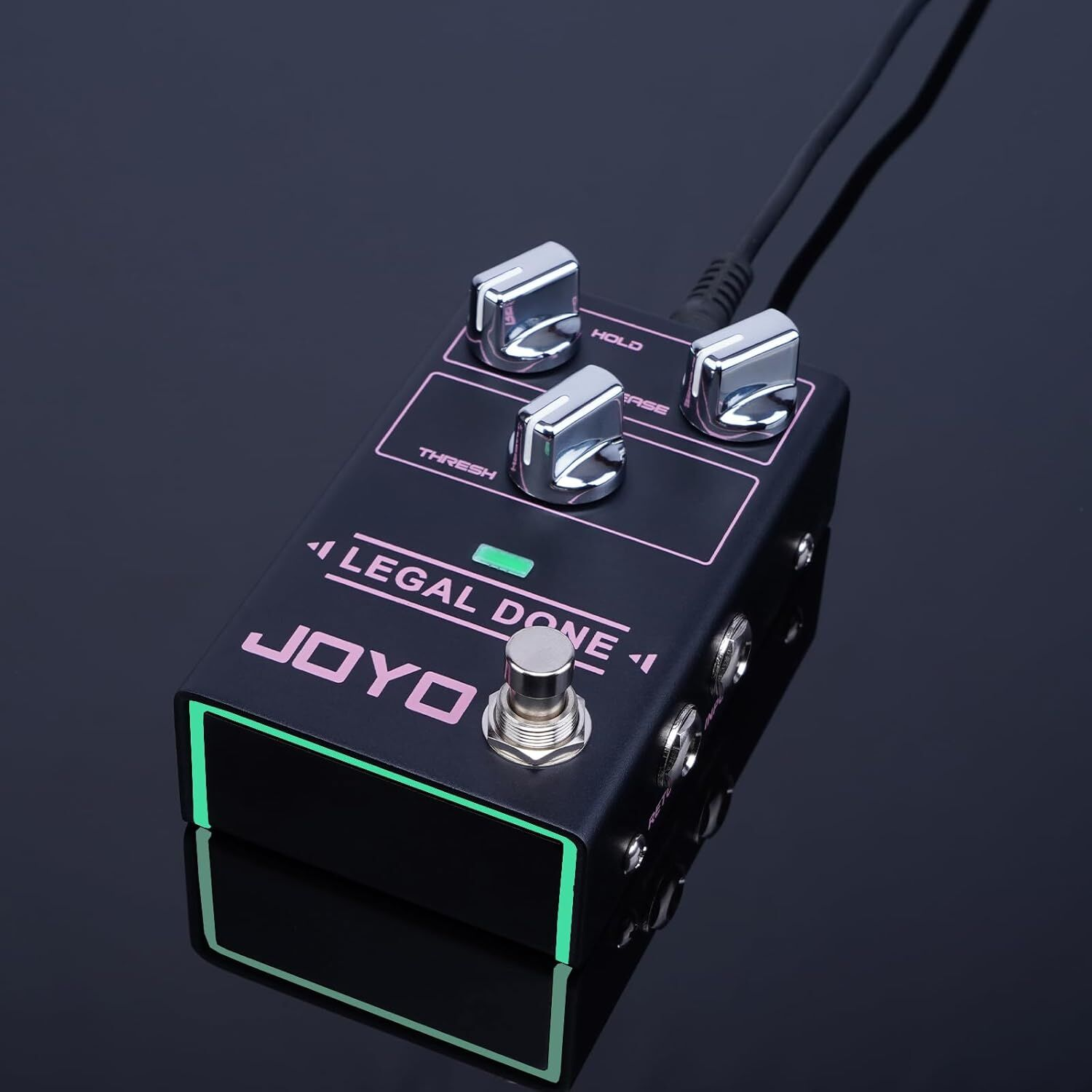 Gümüş düğmeli ve yeşil kenarlı siyah JOYO Legal Done pedal. Kablo bağlı.