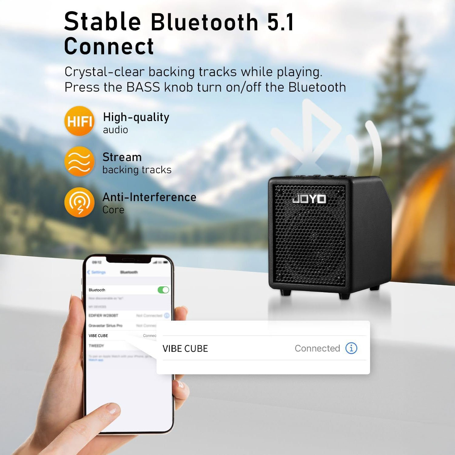 Bağlı bir telefonun yanında siyah bir Bluetooth hoparlör. Dağlık arka plan.