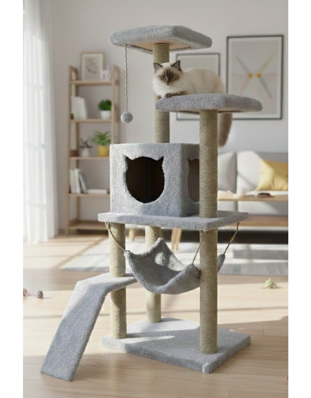 Bir kedi, hamaklı ve oyuncaklı gri kedi ağacında oturuyor.