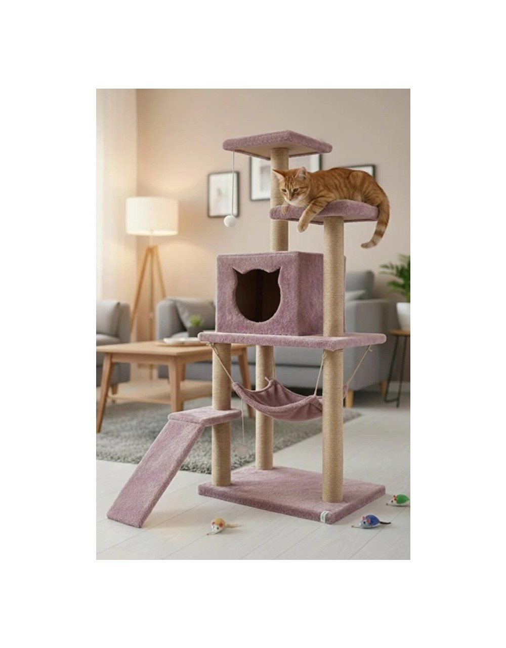 Turuncu bir kedi, hamaklı ve rampalı çok katlı pembe bir kedi ağacında dinleniyor. Yerde oyuncak fareler var.