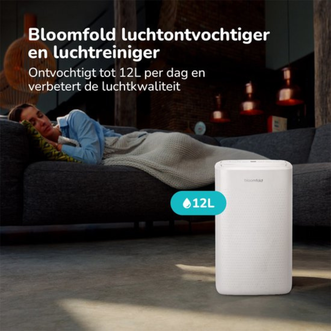 Een vrouw slaapt op een bank naast een witte 12L luchtontvochtiger.