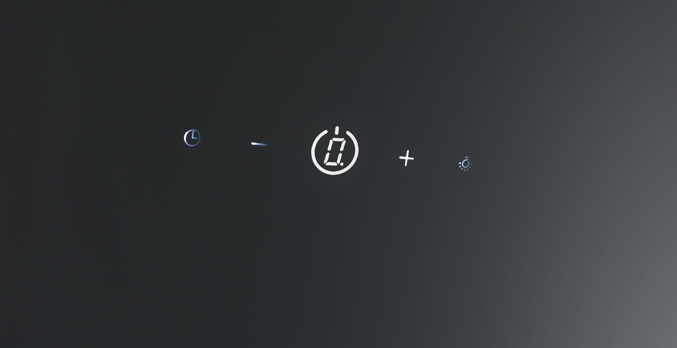 Bedienfeld mit Symbolen: Uhr, Minus, Ziffer 0, Plus, Lampe.