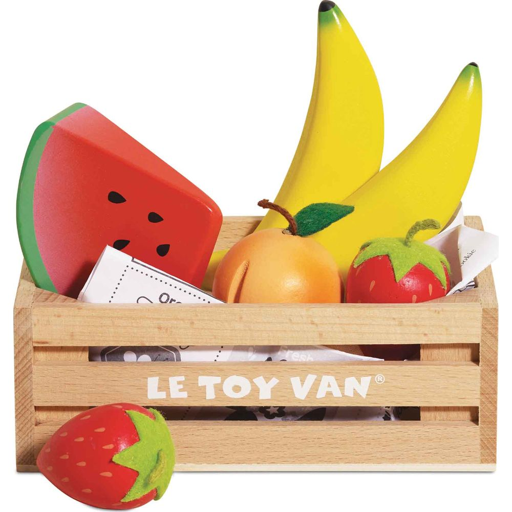 Holzkiste mit Spielzeugfrüchten: Wassermelone, Bananen, Apfel und Erdbeeren.