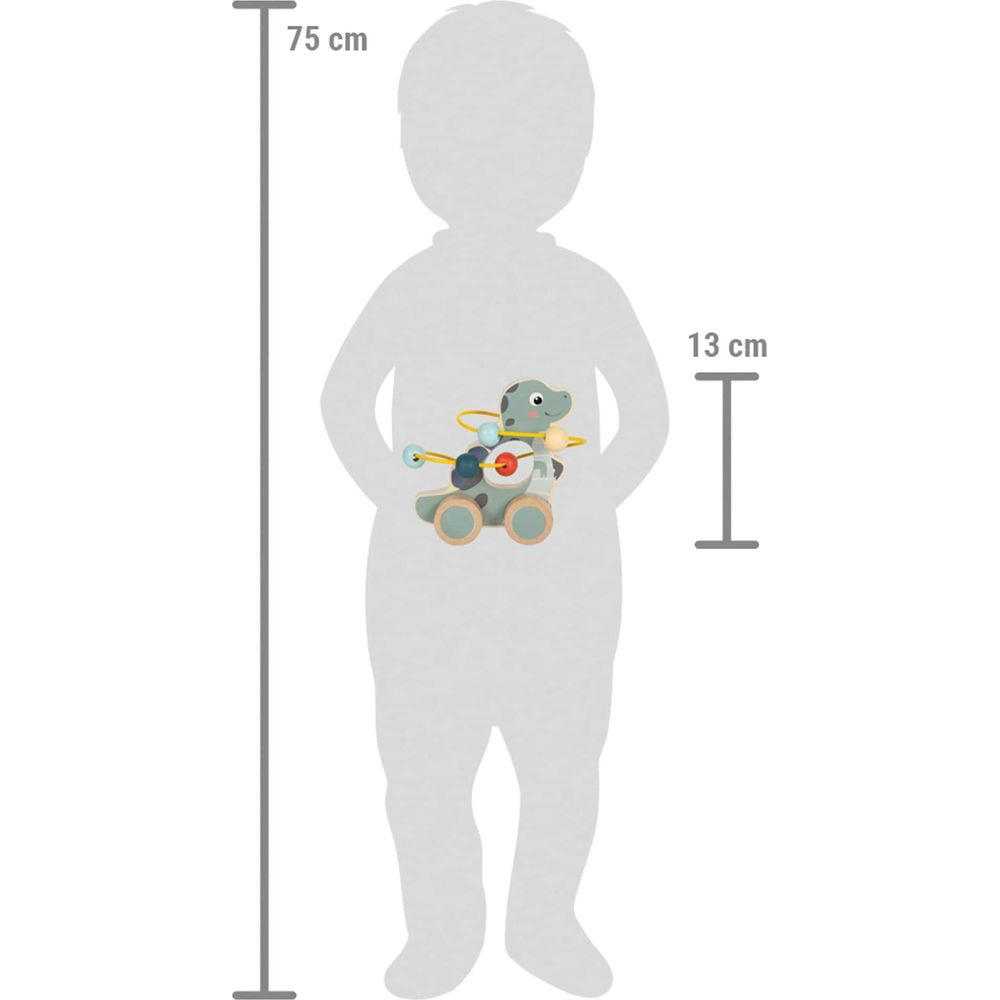 Un jouet dinosaure à roues et perles colorées sur le ventre d'un enfant.