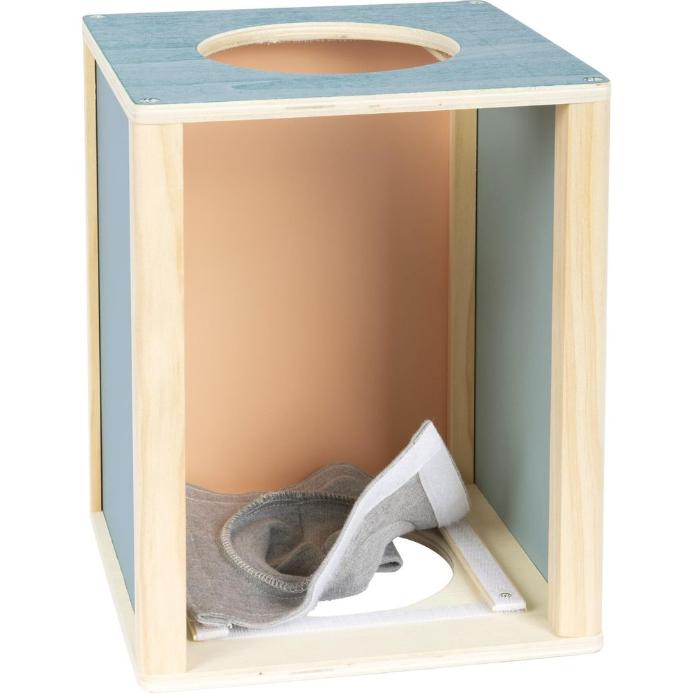 Cube en bois avec trou rond sur le dessus et tissu gris à l'intérieur.