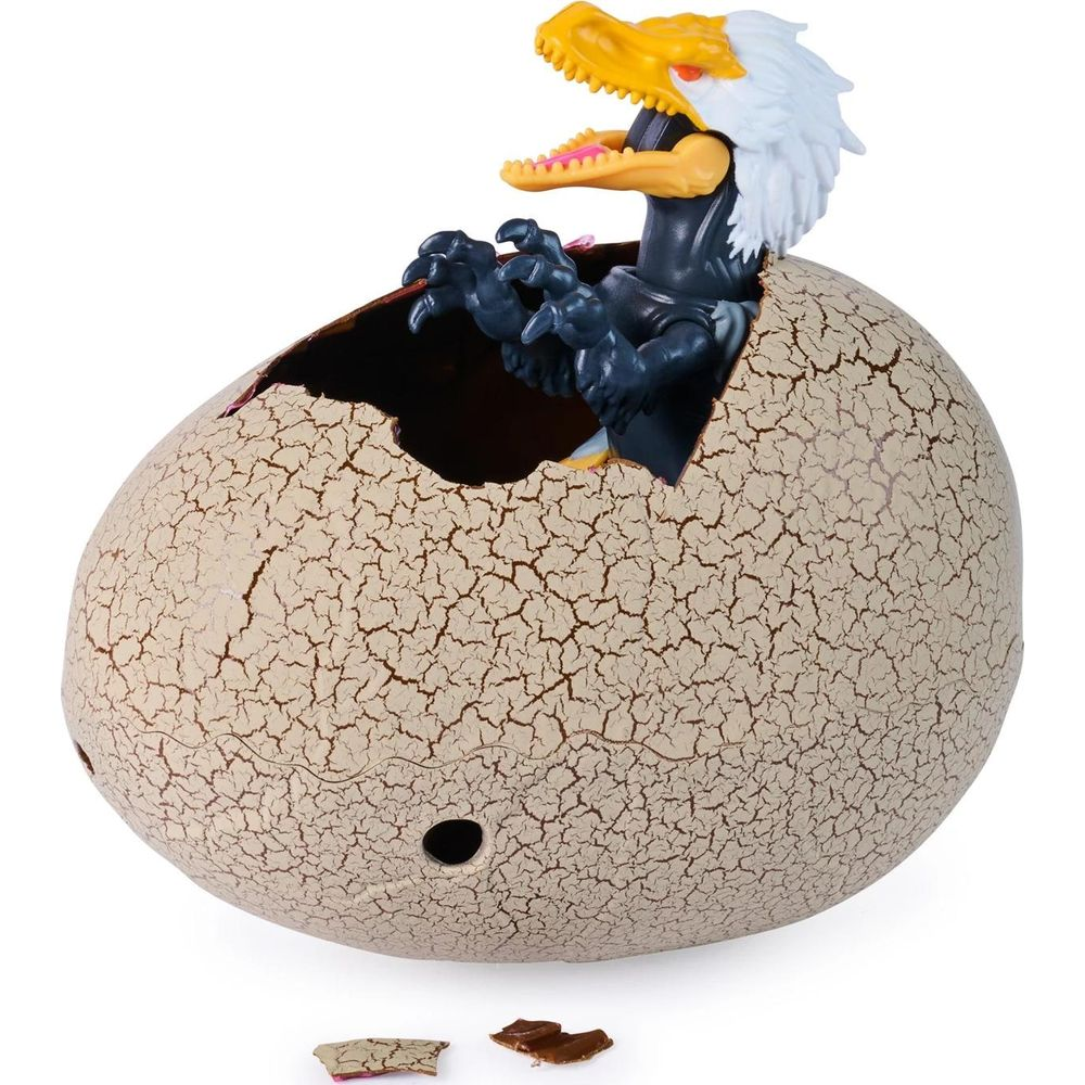 Un dinosaurio de juguete con pico amarillo y plumas blancas sale de un huevo roto.
