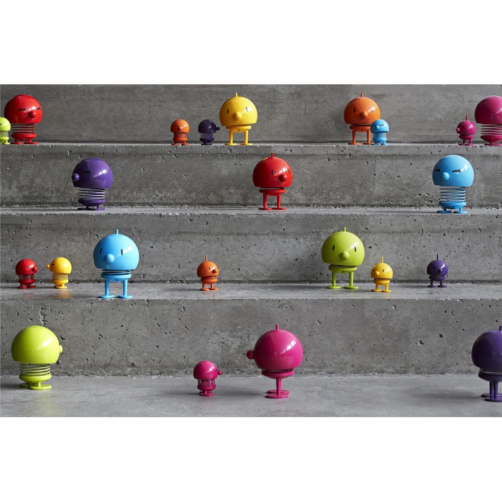 Figure colorate con testa a molla su scale di cemento. Varie dimensioni e colori.