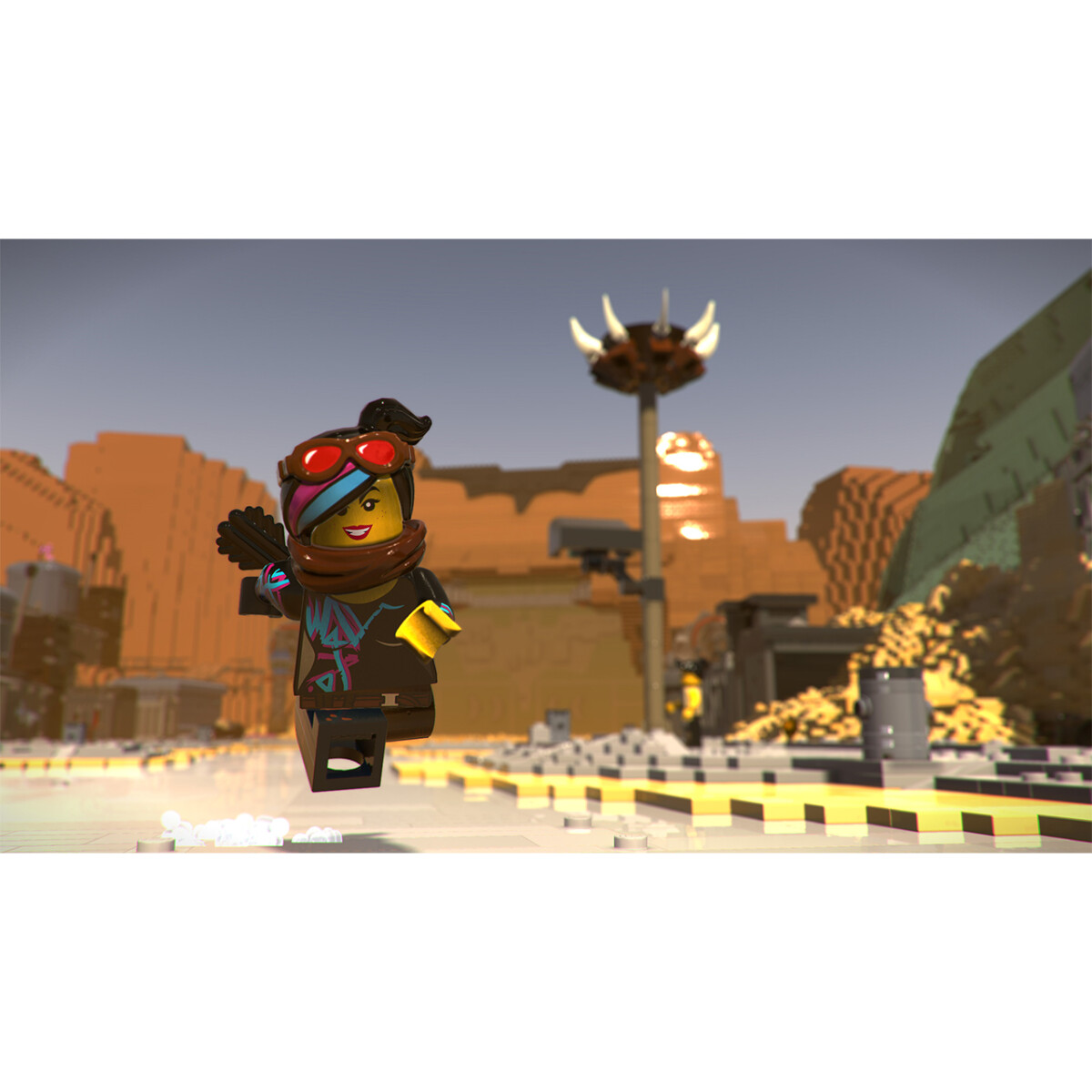 Eine Lego-Figur mit Brille und Schal springt in einer Wüstenlandschaft.