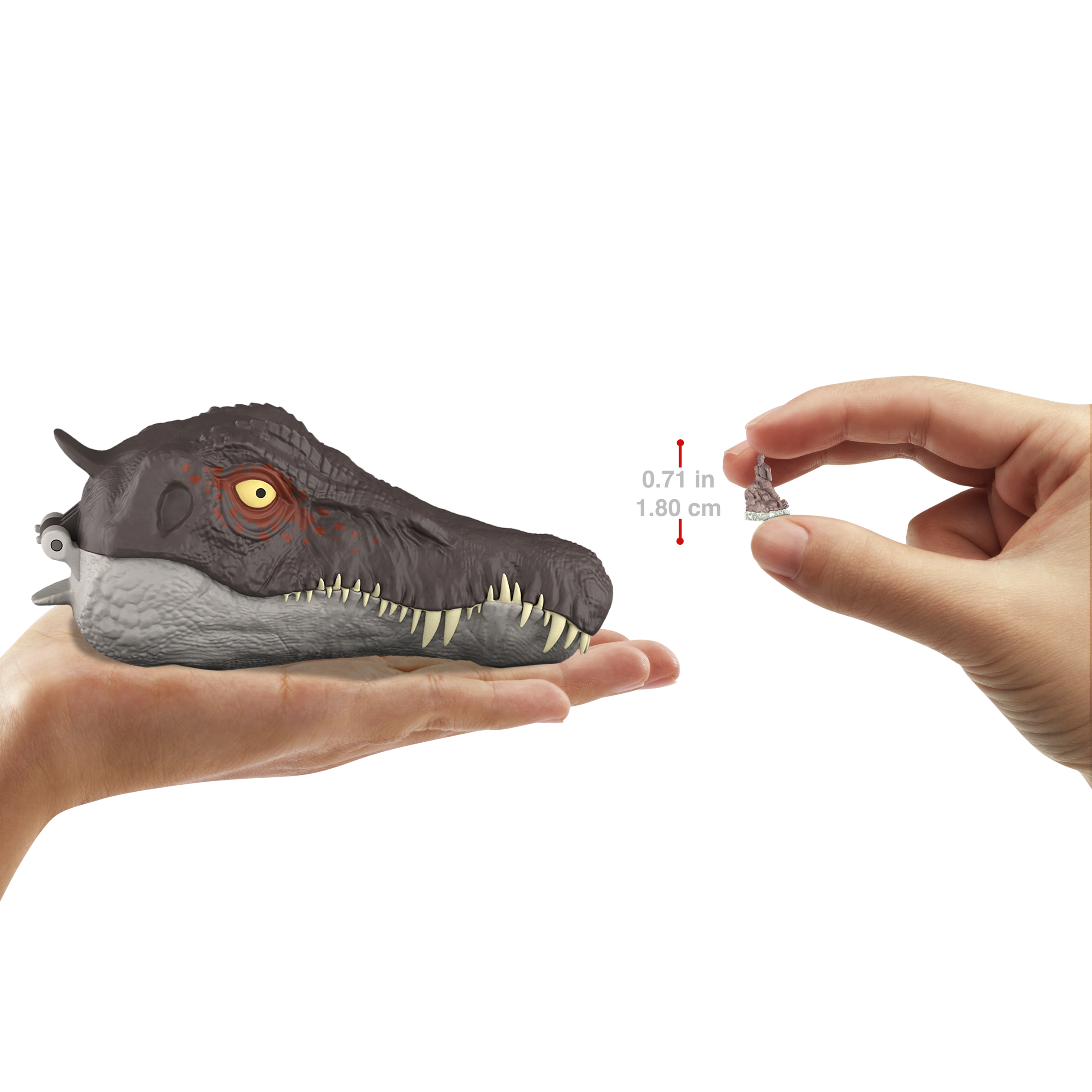 Una mano sostiene una cabeza de dinosaurio de juguete. Otra mano sostiene figura diminuta.