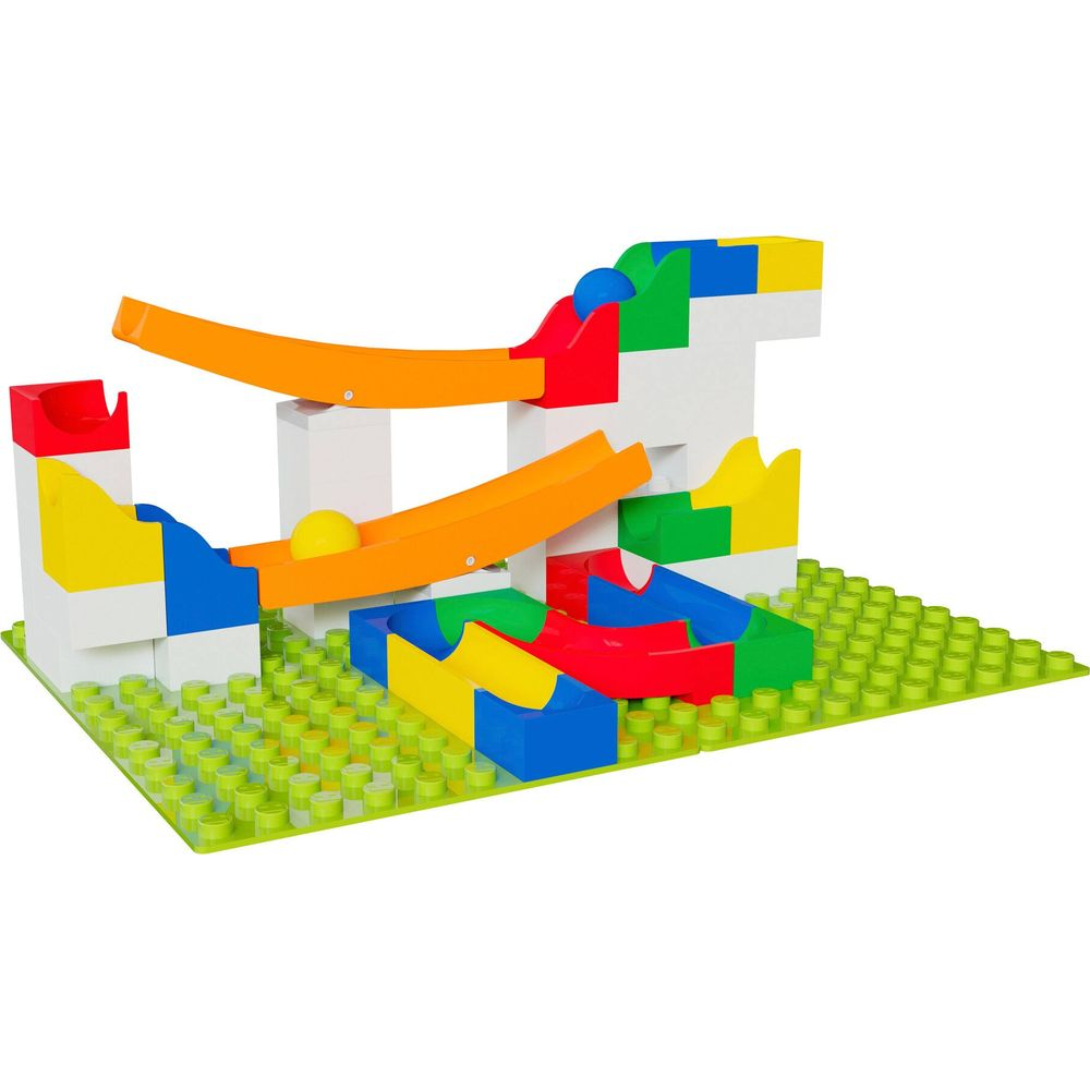 Blocs de construction colorés forment un circuit de billes avec des balles jaunes.