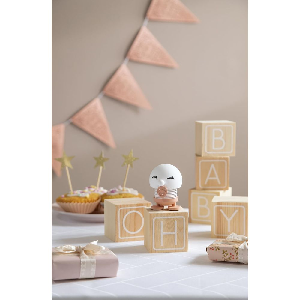 Decorazioni per baby shower: pupazzetto, blocchi con lettere, cupcake e regali.