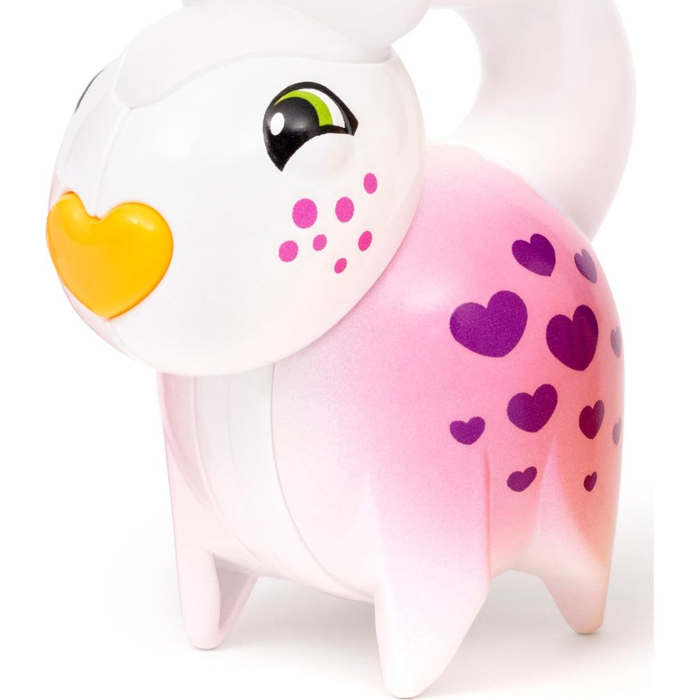Un personnage blanc jouet ressemblant à un lapin avec un nez jaune en forme de cœur et des cœurs roses.