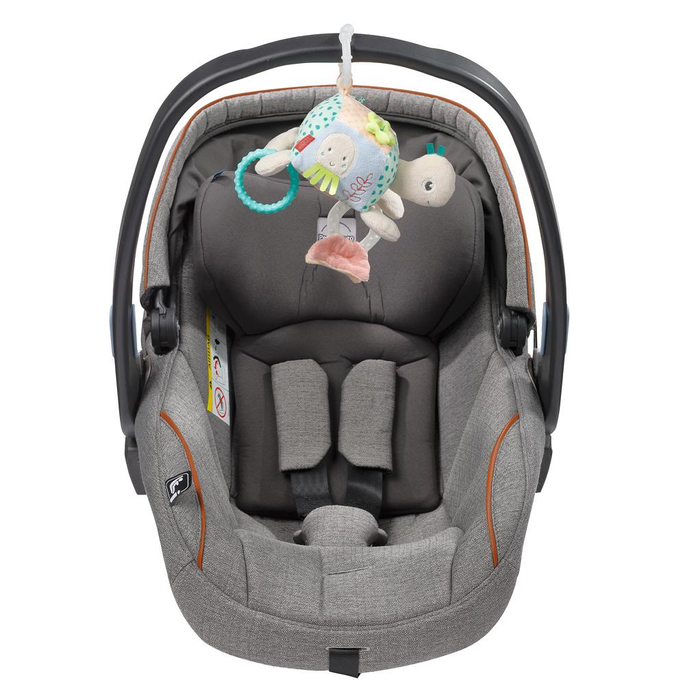 Seggiolino auto grigio con tartaruga giocattolo appesa sopra.