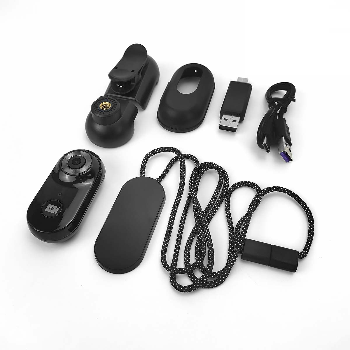 Czarna kamera akcji, klips, etui, adapter USB i kabel ładujący na białym.