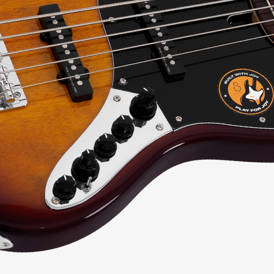 Güneş patlaması bas gitarın gövdesinin yakın çekimi, manyetikleri, düğmeleri ve logosu görünüyor.