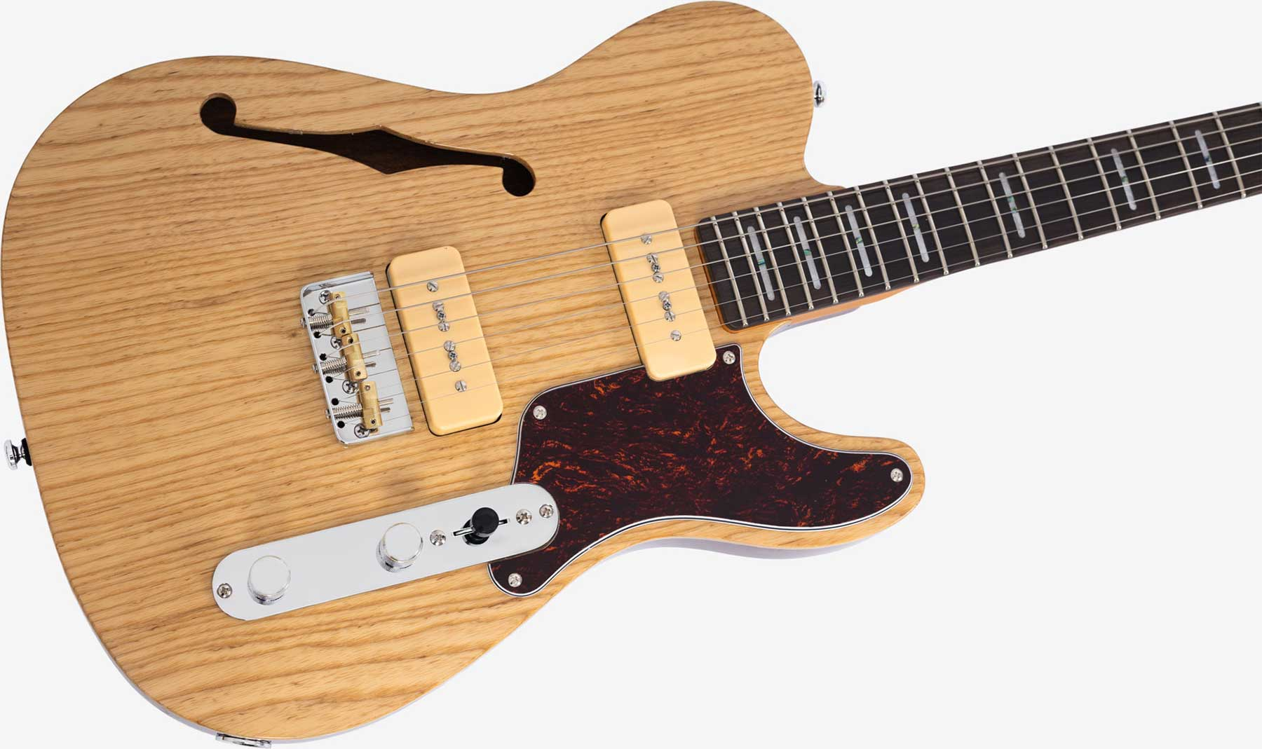 Açık renk ahşap elektro gitarın yakın çekimi, üzerinde iki krem rengi manyetik ve kaplumbağa desenli pena koruyucu bulunur.
